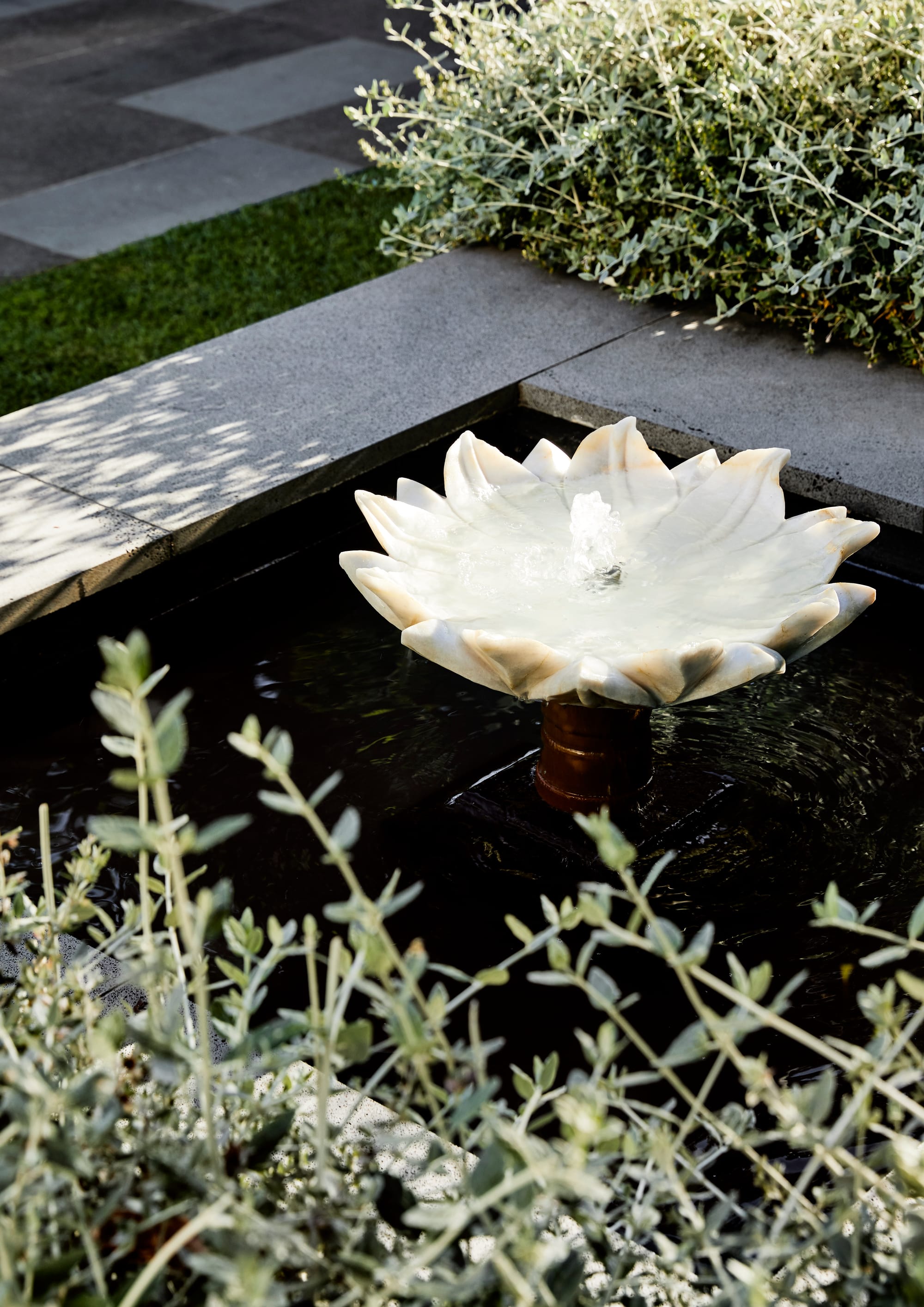 Julie Crowe Landscape Design. Photography by Caitlin Mills Photography.  Lotus flower shaped water fountain in outdoor garden. 