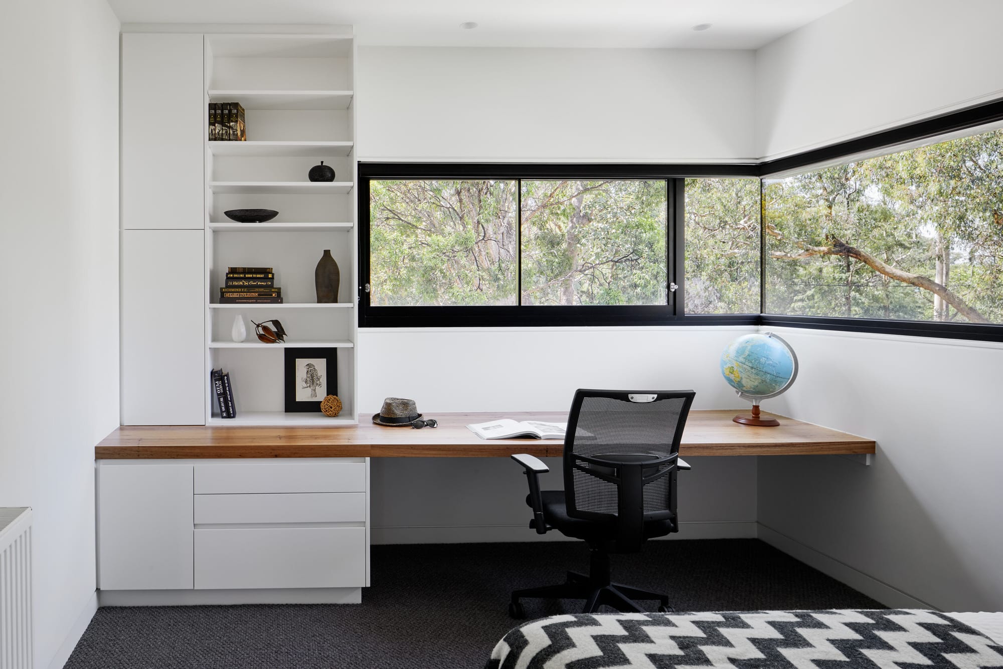 Laurel Grove by Kirsten Johnstone Architecture. Photography by Tatjana Plitt. Second floor bedroom with integrated timber bench and storage underneath window, overlooking gum trees. 