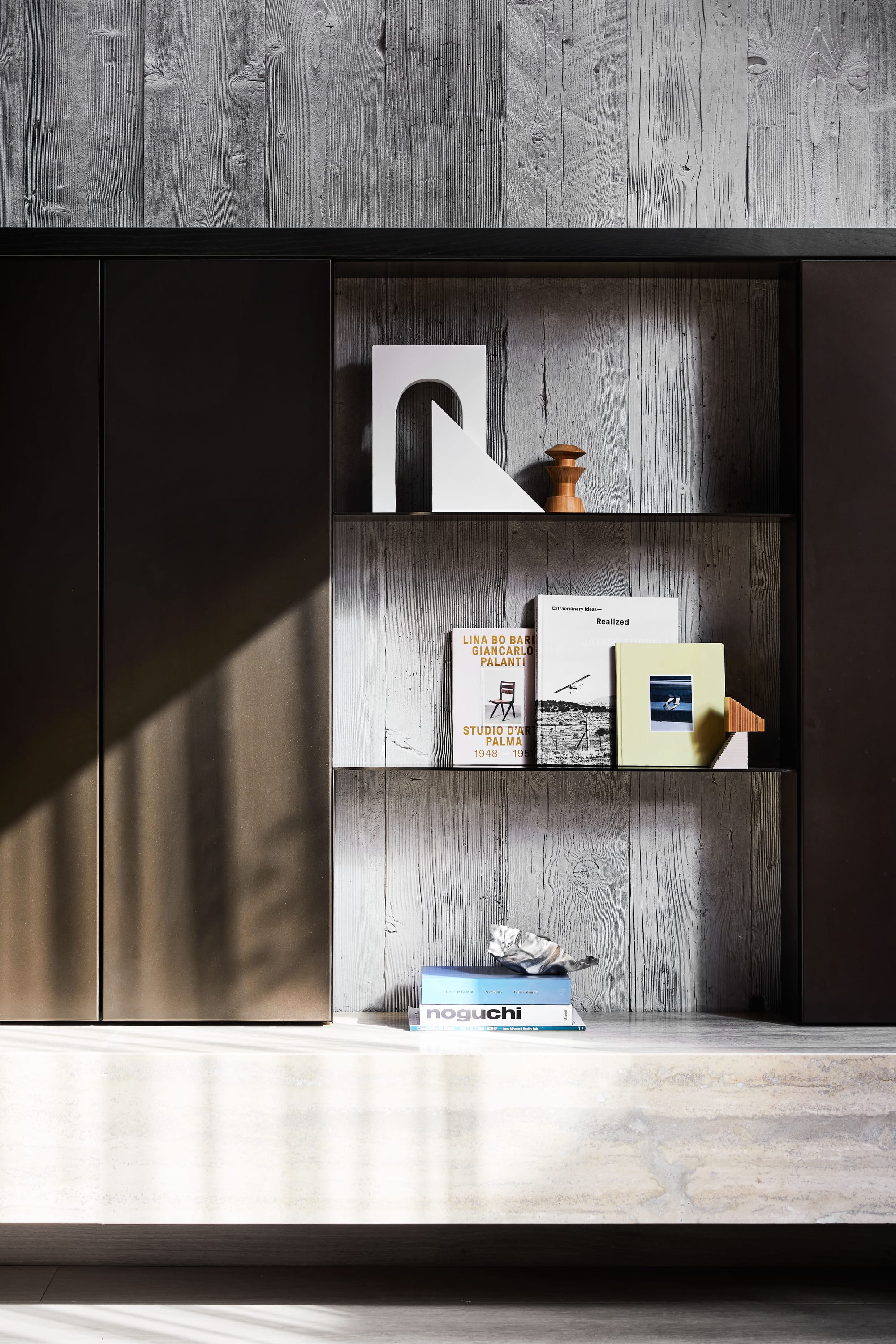The Split Home by Seidler Group. Copyright of Seidler Group. Integrated bookshelf made of black metal and timber-look concrete. 