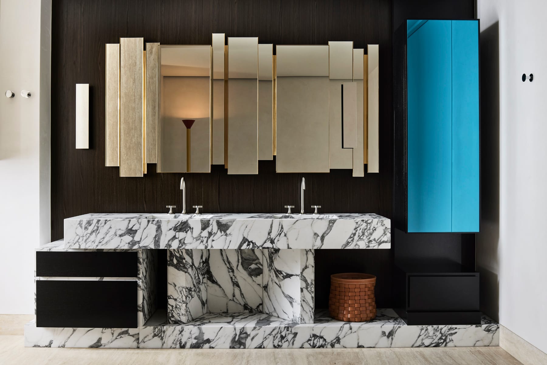Toorak House 2 by K.P.D.O. Photography by Sharyn Cairns. White and black marble basin and sink. Art deco inspired mirror on wall. Blue storage cabinet. 