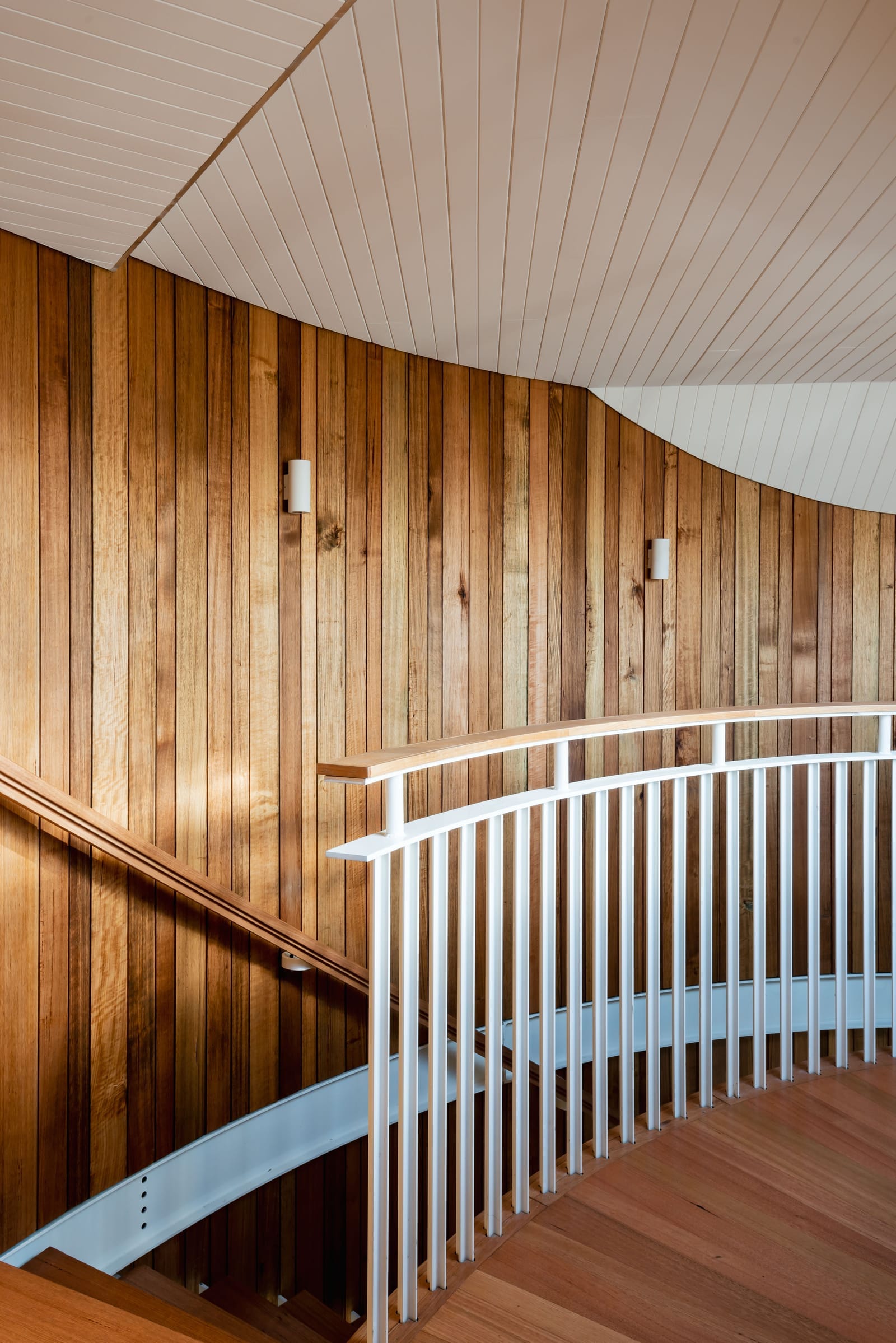 Wattle Bird House by Flett Architecture. Photography by Matt Sansom. Curved timber staircase with metal balustrade. Timber floors and timber walls.