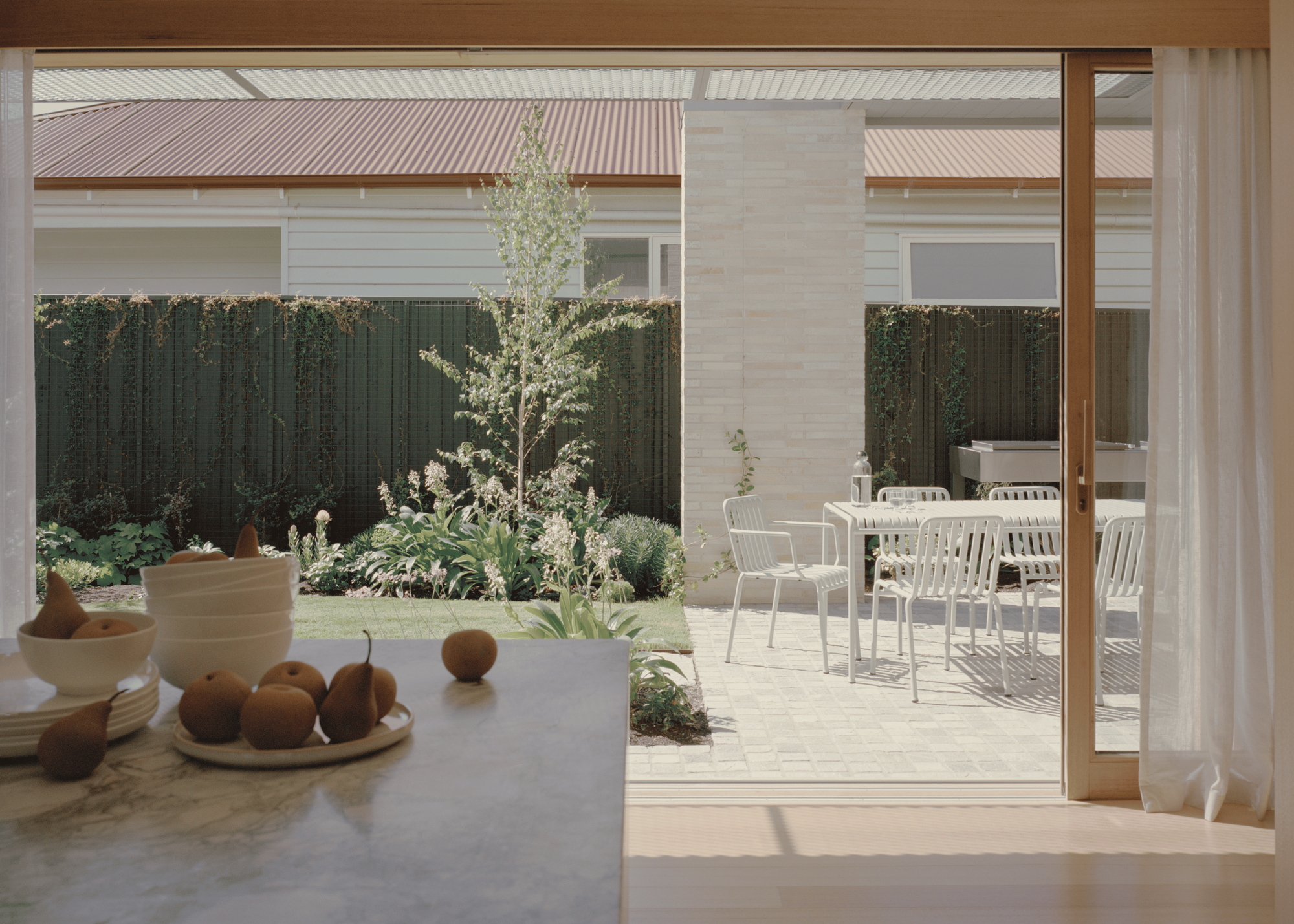 Gable Park by Weaver+Co Architects. Photography by Tasha Tylee. Second floor of home visible through foliage. 