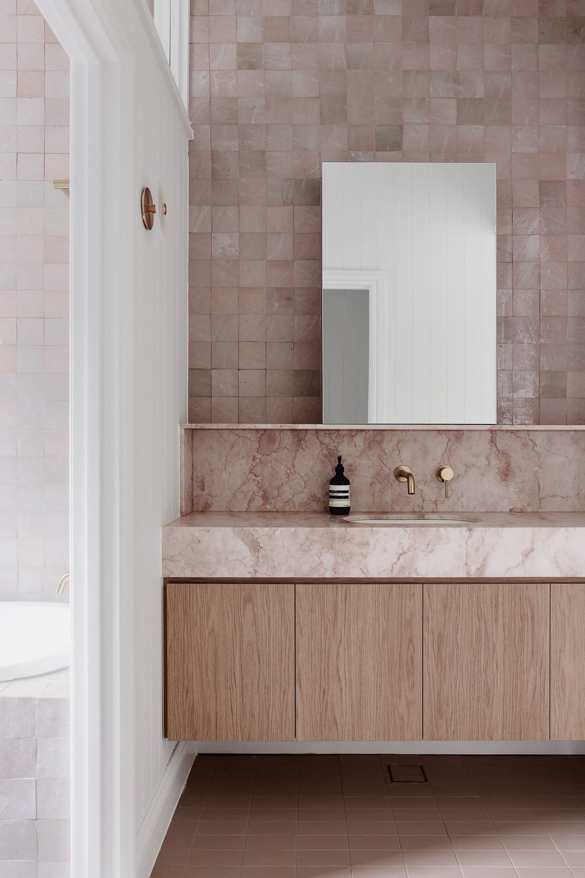 Hazlewood House by Favell Architects. Photography by Andy Macpherson. Bathroom with pink marble countertop and splashback. Timber cabinetry. Pink floor and wall tiles. 