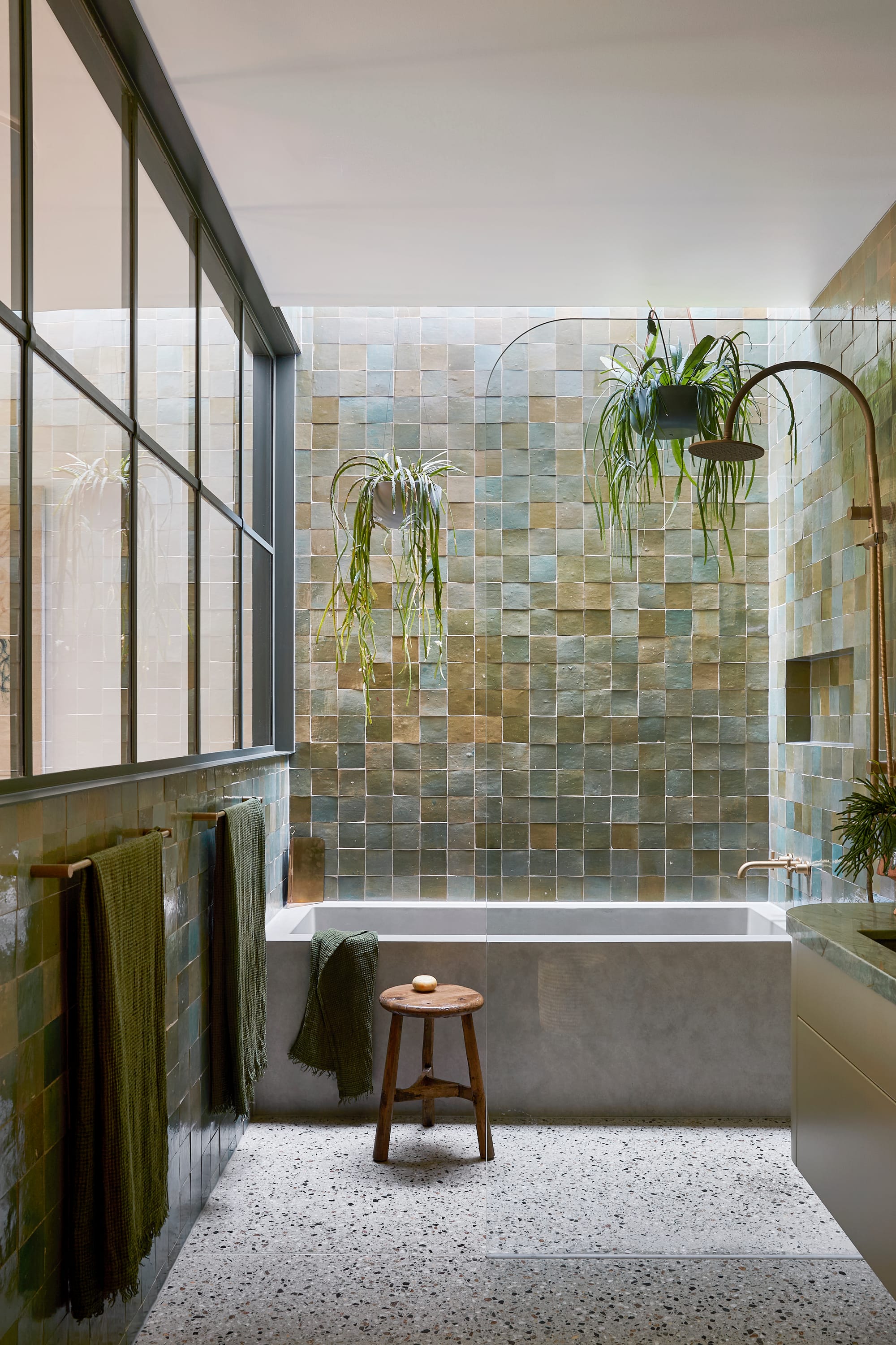 Fabrica by mcmahon and nerlich. Photography by Shannon McGrath. Ensuite with green wall tiles and concrete tub. Terrazzo floor times, hanging plants in shower. 
