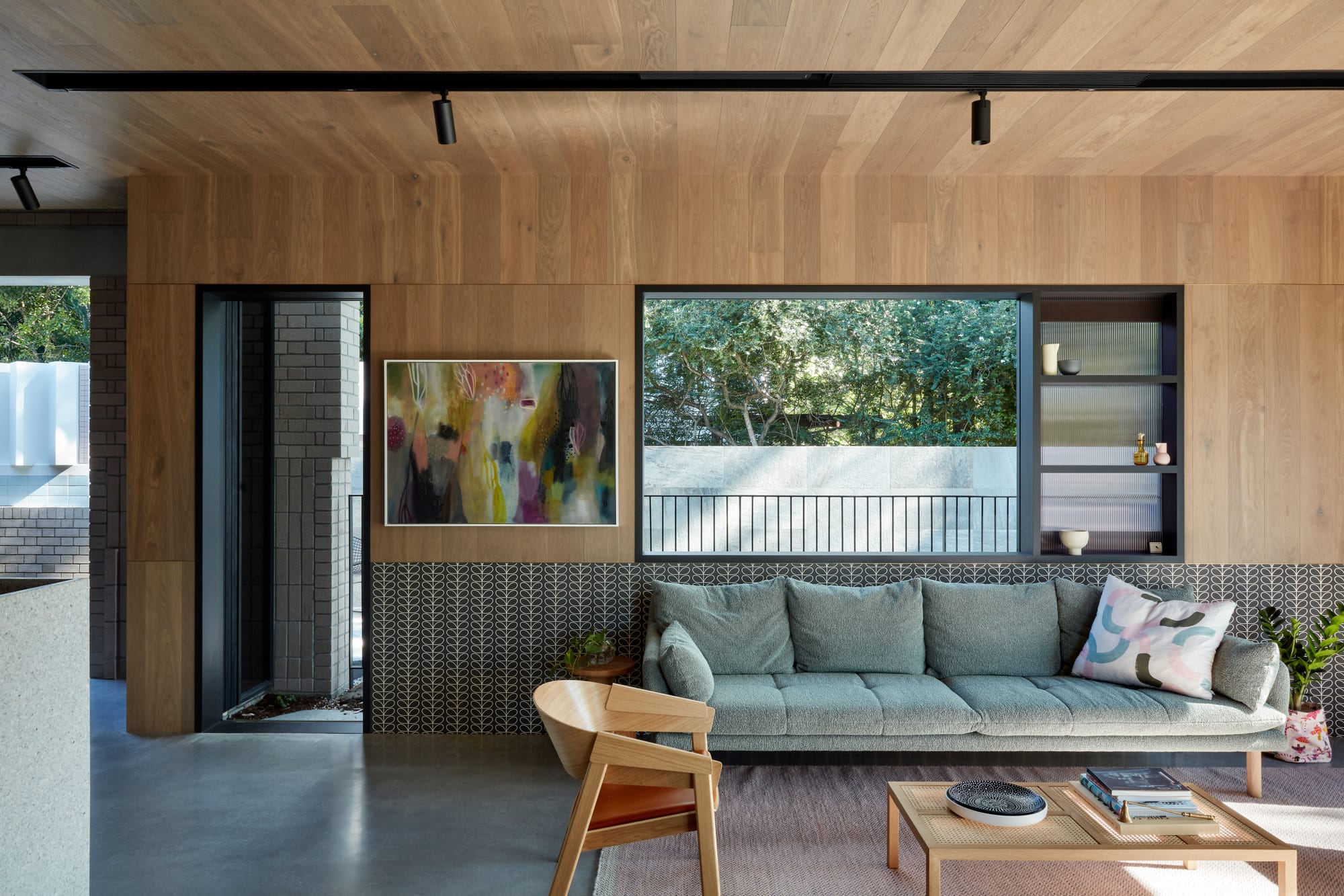 Uxbridge House by Tim Stewart Architects. Photography by Christopher Frederick Jones. Living room with wood walls and ceiling and polished concrete floor. Grey couch with timber coffee table. 