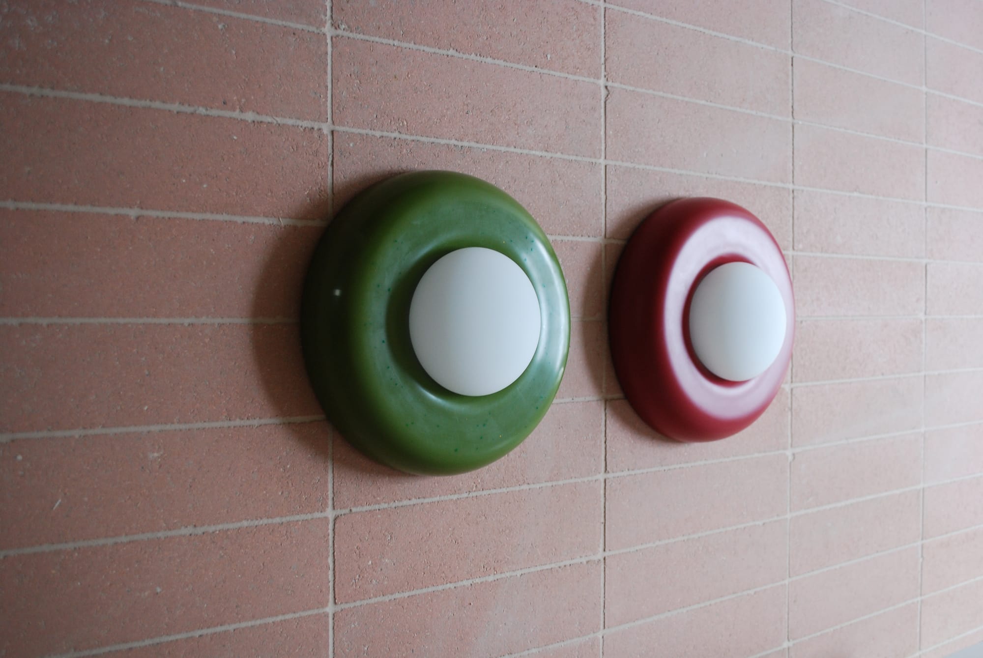 ChromaBlock Wall Sconces in red and green on a red tile wall