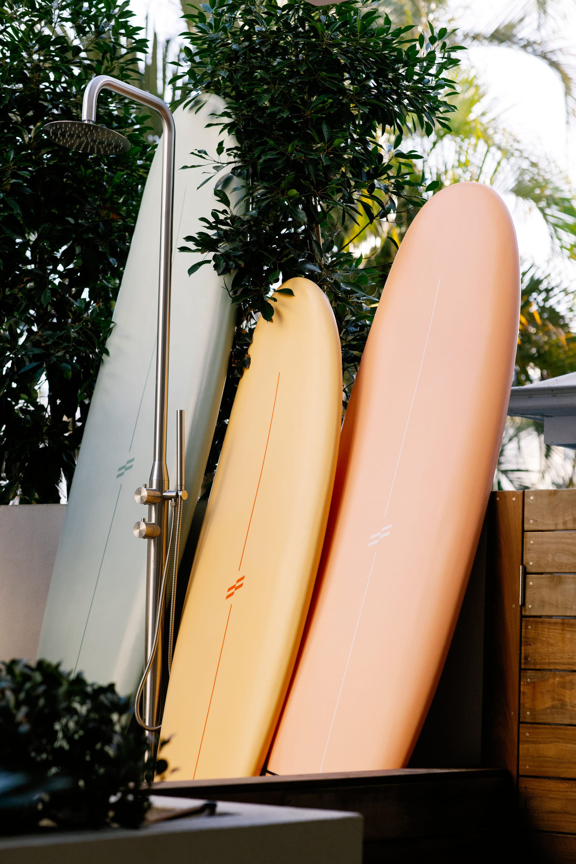 Basq House. Photography by Elise Hassey.  Surfboards leaning against timber fence behind outdoor shower.