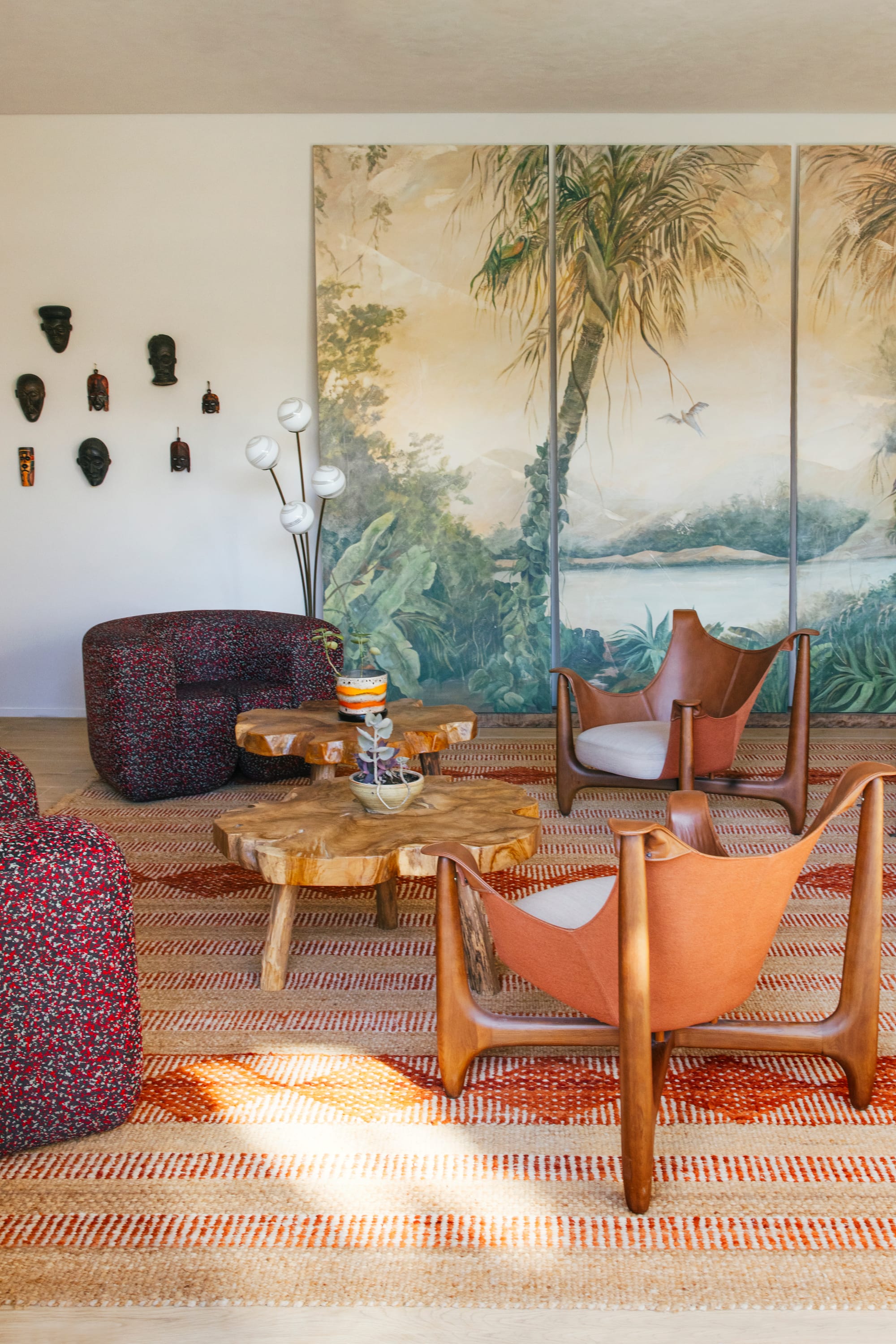 Basq House. Photography by Elise Hassey. Hotel living space with eclectic chairs, raw timber coffee tables and patterned rug. Large mural on wall.