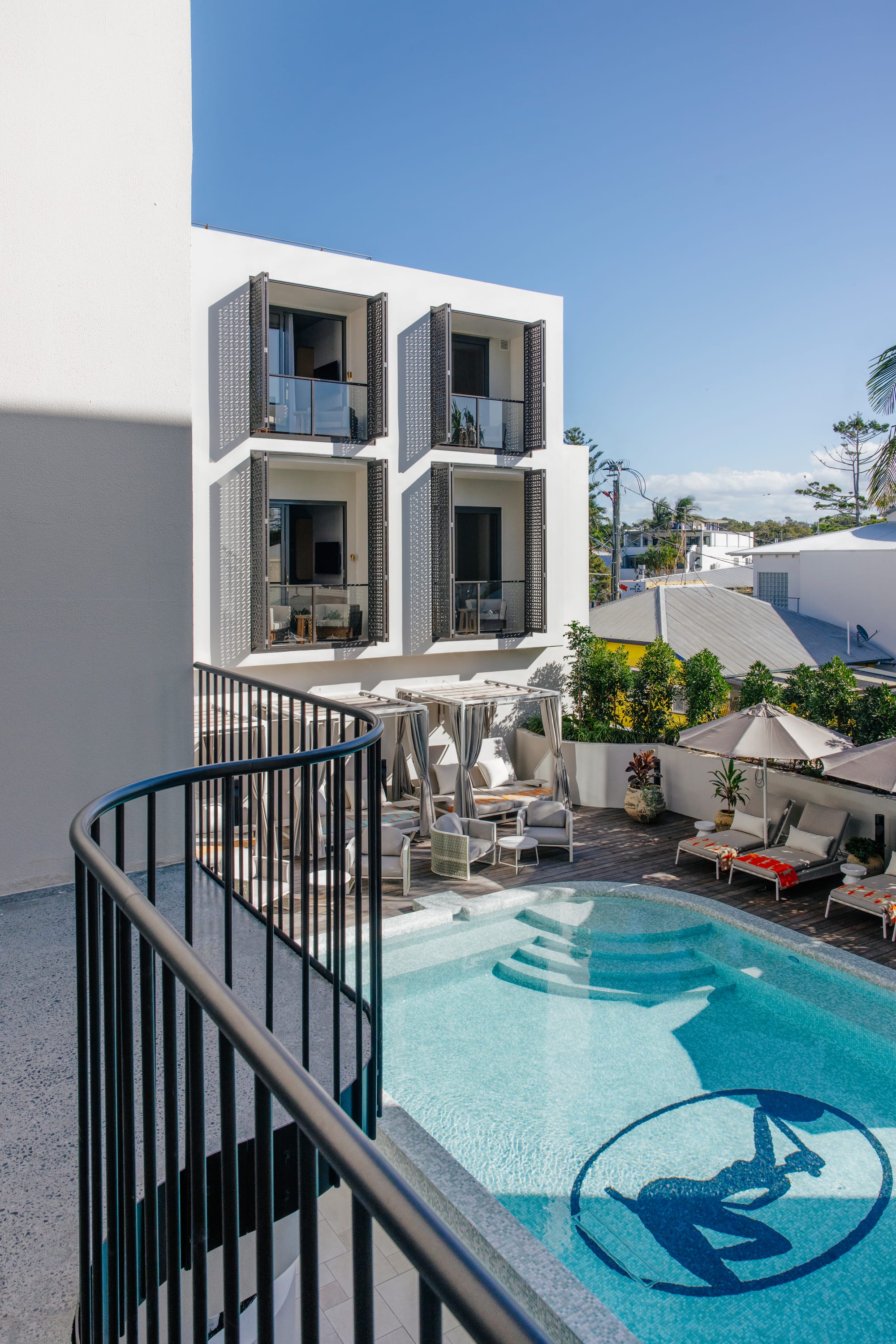 Basq House. Photography by Elise Hassey. Canopy pool beds in front of raised tiled pool. 