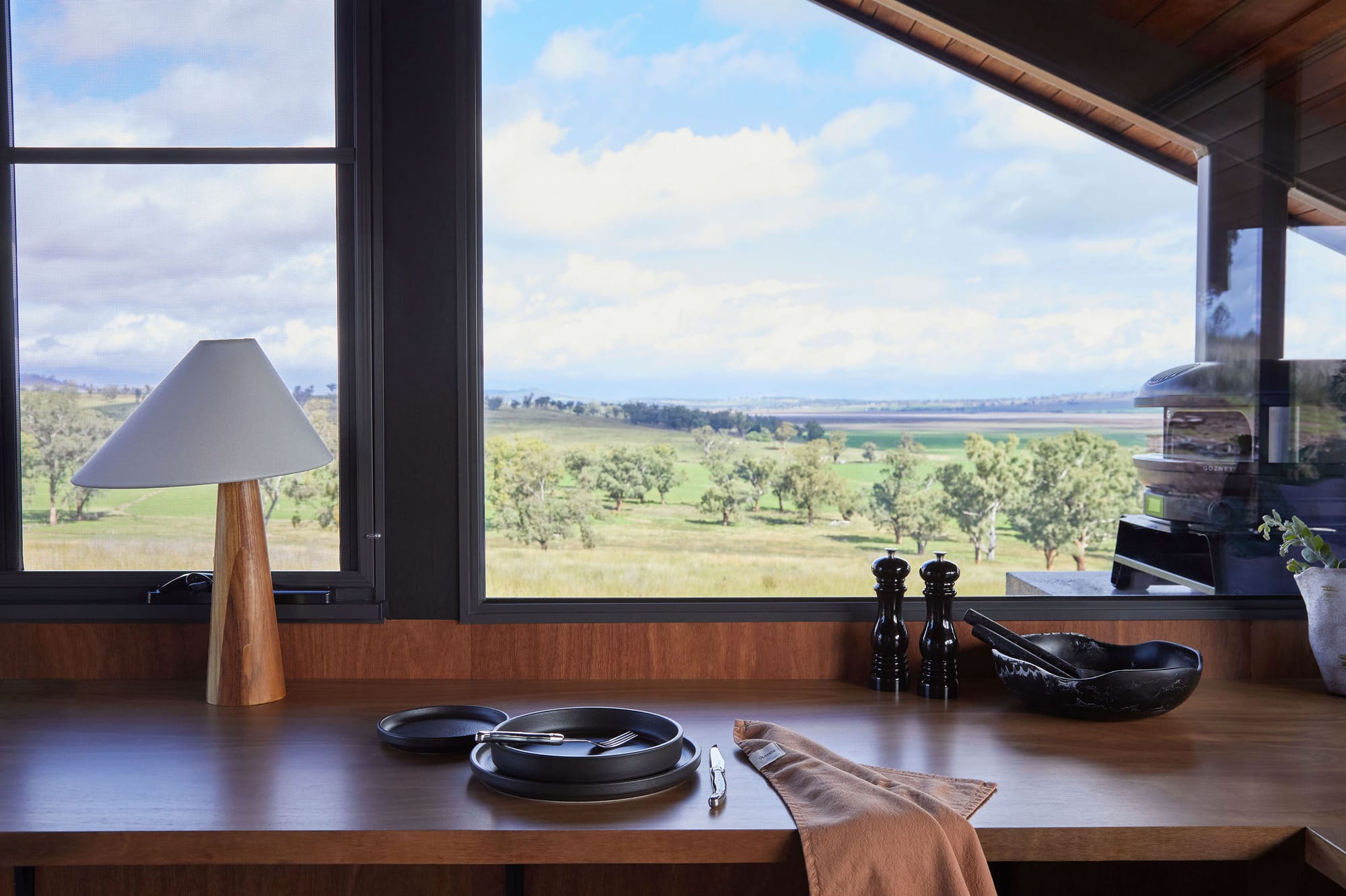 Gilay Estate by Cameron Anderson Architects. Photography by Morning Swim. Angled window over timber counter looking out onto rolling hills.