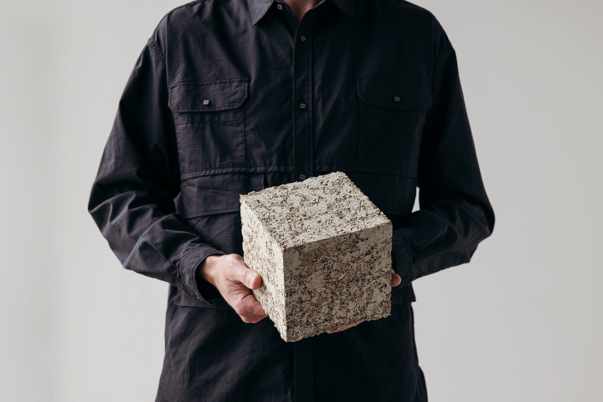 Otetto. Image copyright of Otetto. Man in black button down shirt holding hemp block in front of neutral backdrop.