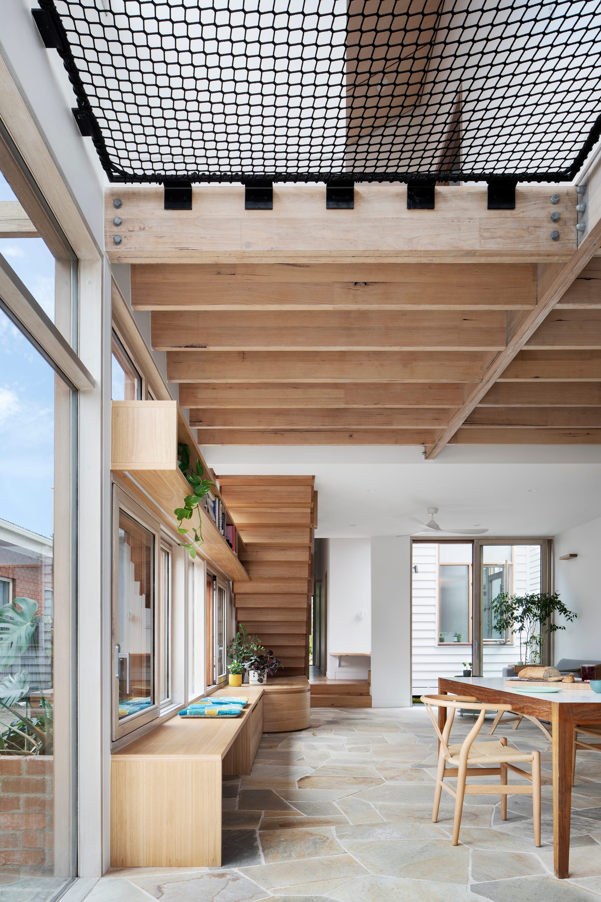 An interior shot showing the crazy paving in the kitchen and dining space with a net void space above