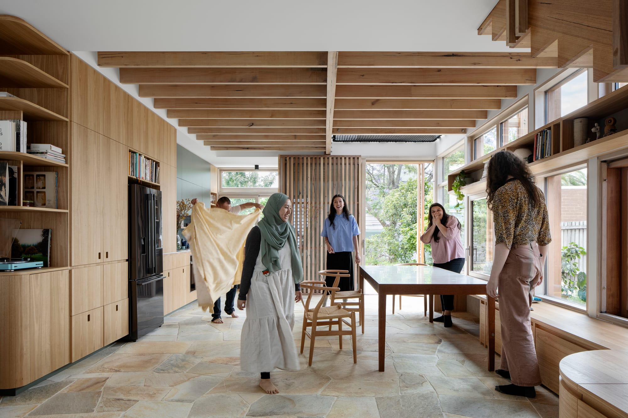 An interior shot showing five people using the dining and kitchen space