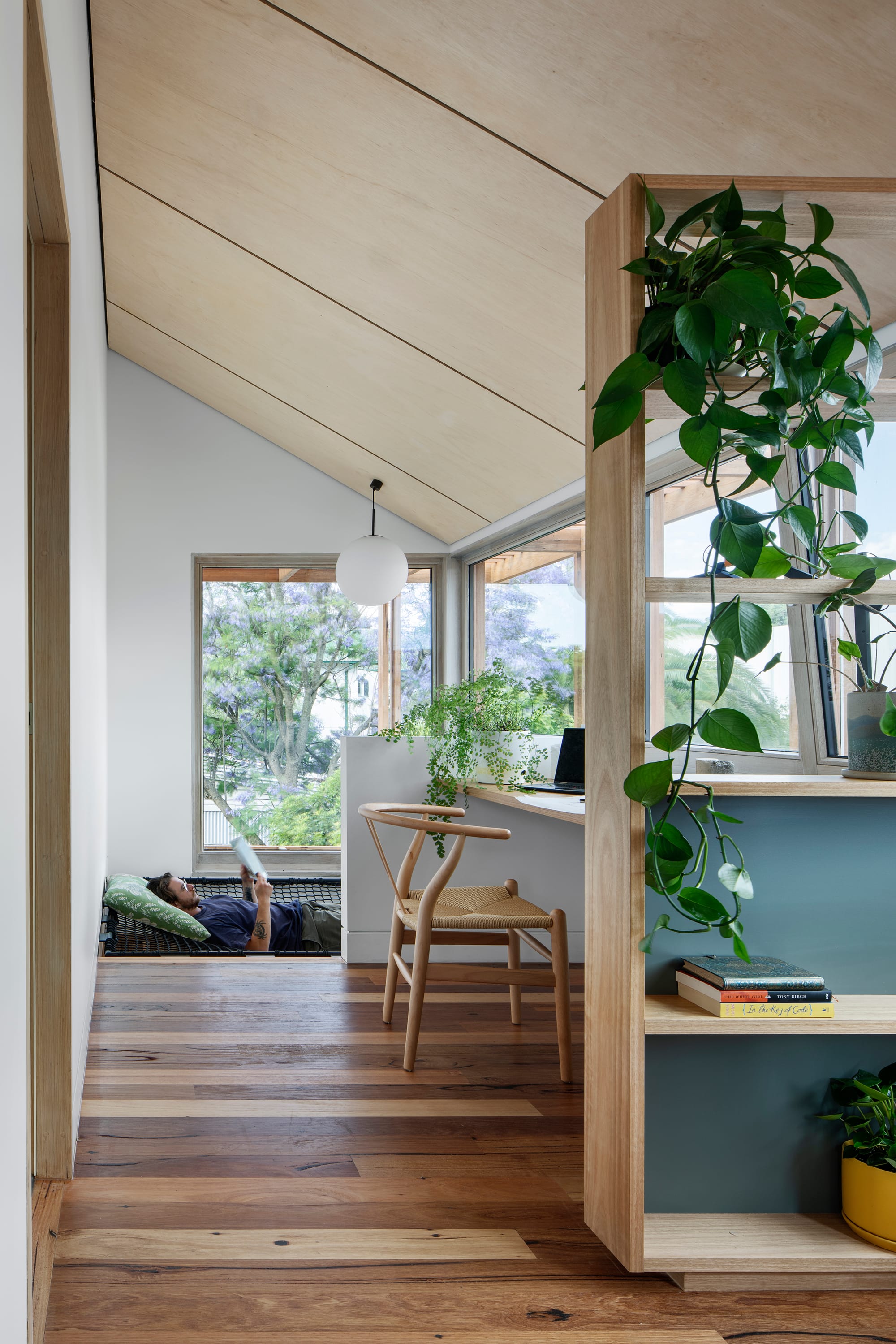 An interior shot of a home office with net seating with a man reading a book