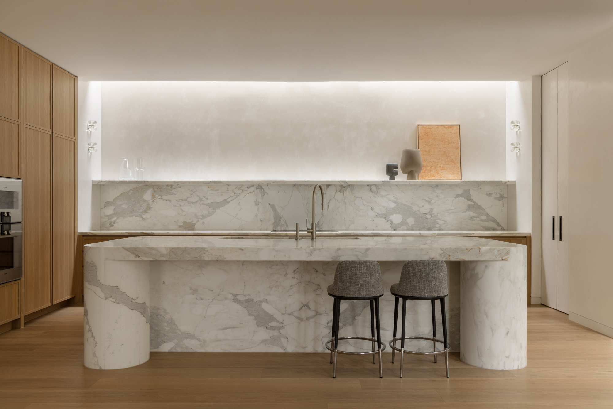 An interior shot of the kitchen at Balwyn House showing the white marble island bench and timber joinery
