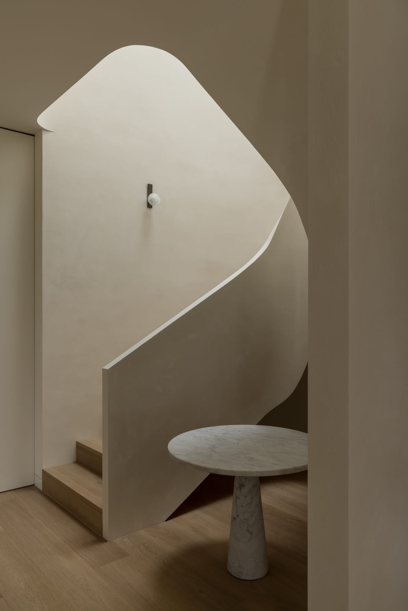 An interior shot of the staircase with a rendered handrail and timber floor as stair treads and a feature wall light