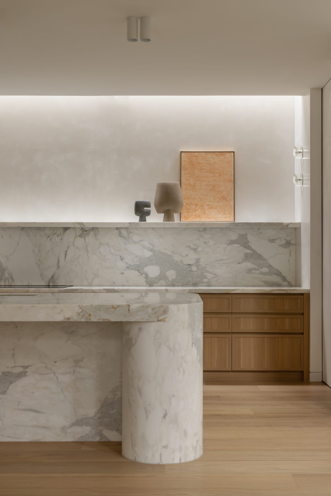 An interior shot of the kitchen at Balwyn House showing the white marble island bench and timber joinery