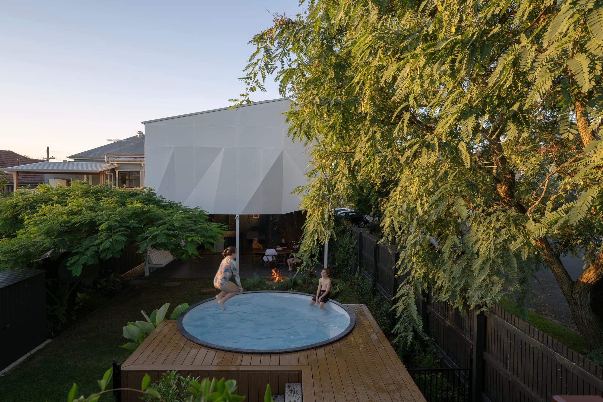 Cornerstone by Loupe Architecture. Photography by Alanna Jayne McTiernan. Outdoor raised circle pool with green garden and white perforated steel screen in background. 