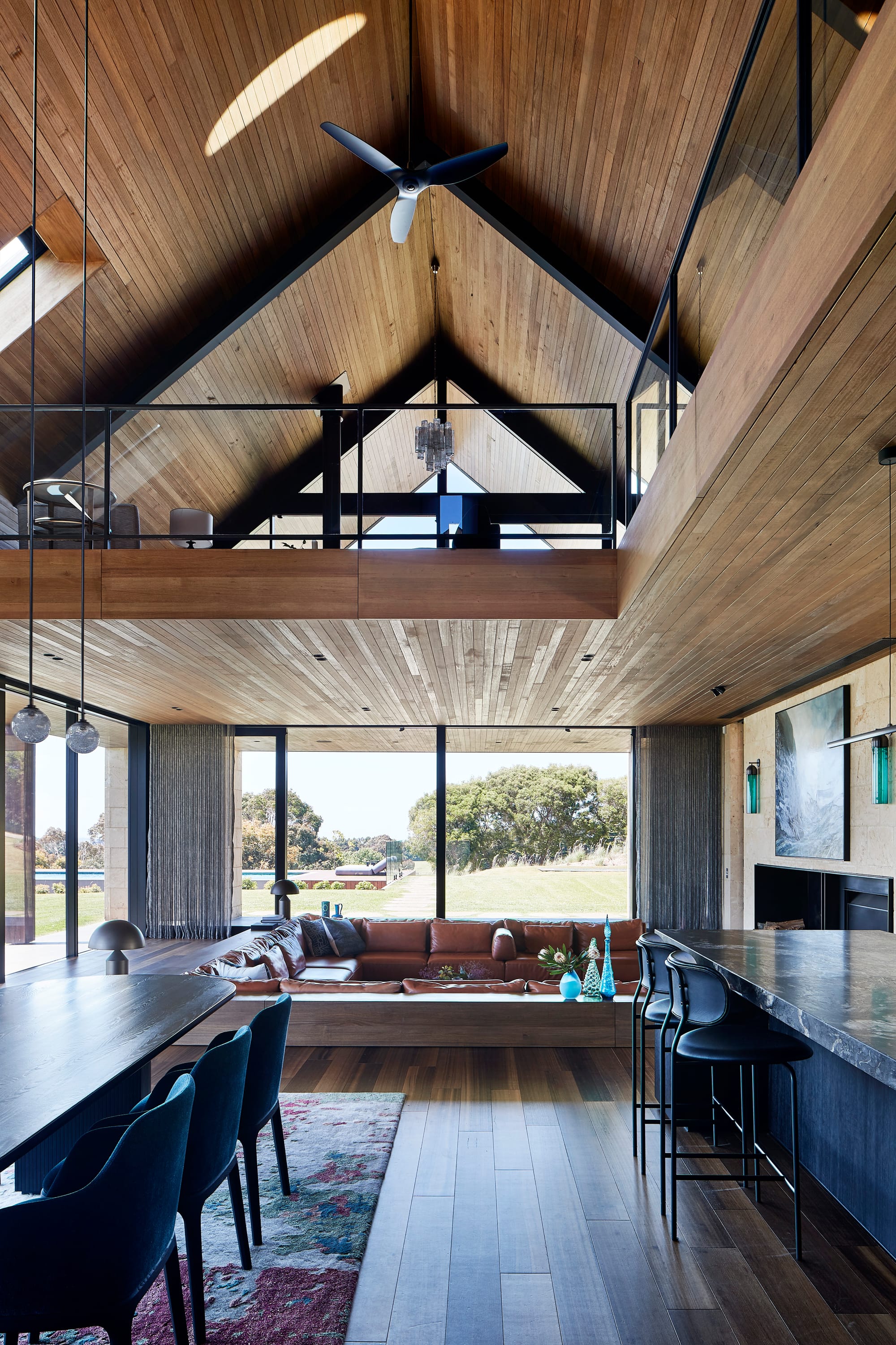 Tasmanian Timber in Flinders Residence by Abe McCarthy. Photography by Shannon McGrath. Multistorey residential home with large exposed void and walkways on second floor. Timber used throughout on floors, ceilings, counter and dividing walls.