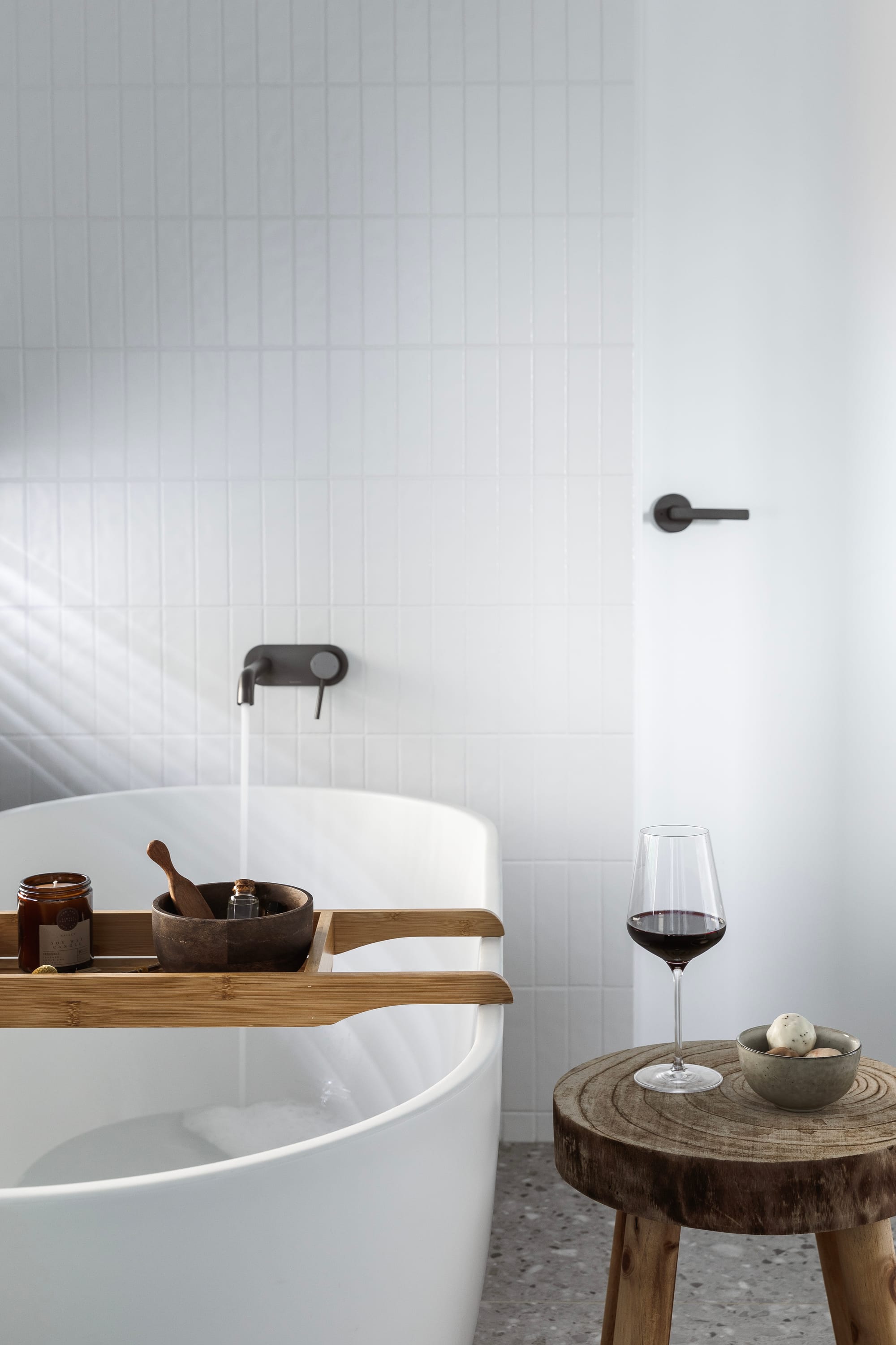 Forrest Haus Retreat. Images copyright of Forrest Haus Retreat. Freestanding white bathtub on terrazzo flooring in front of white subway tile walls. 