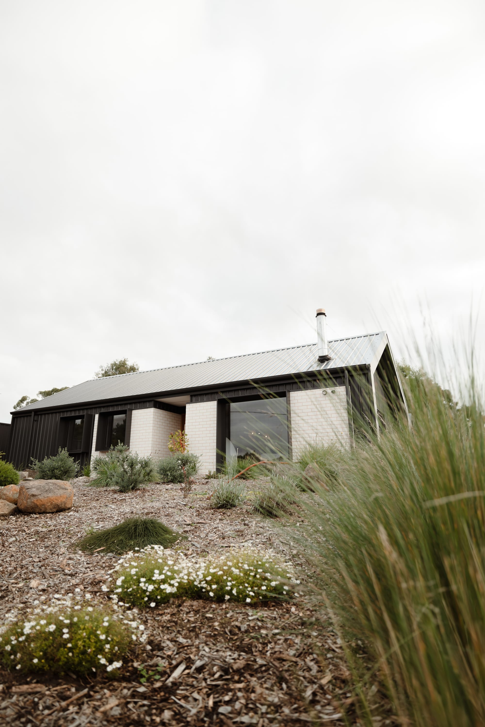 Forrest Haus Retreat. Images copyright of Forrest Haus Retreat. An exterior shot of the retreat looking up from the garden and showing the white brick walls and large windows