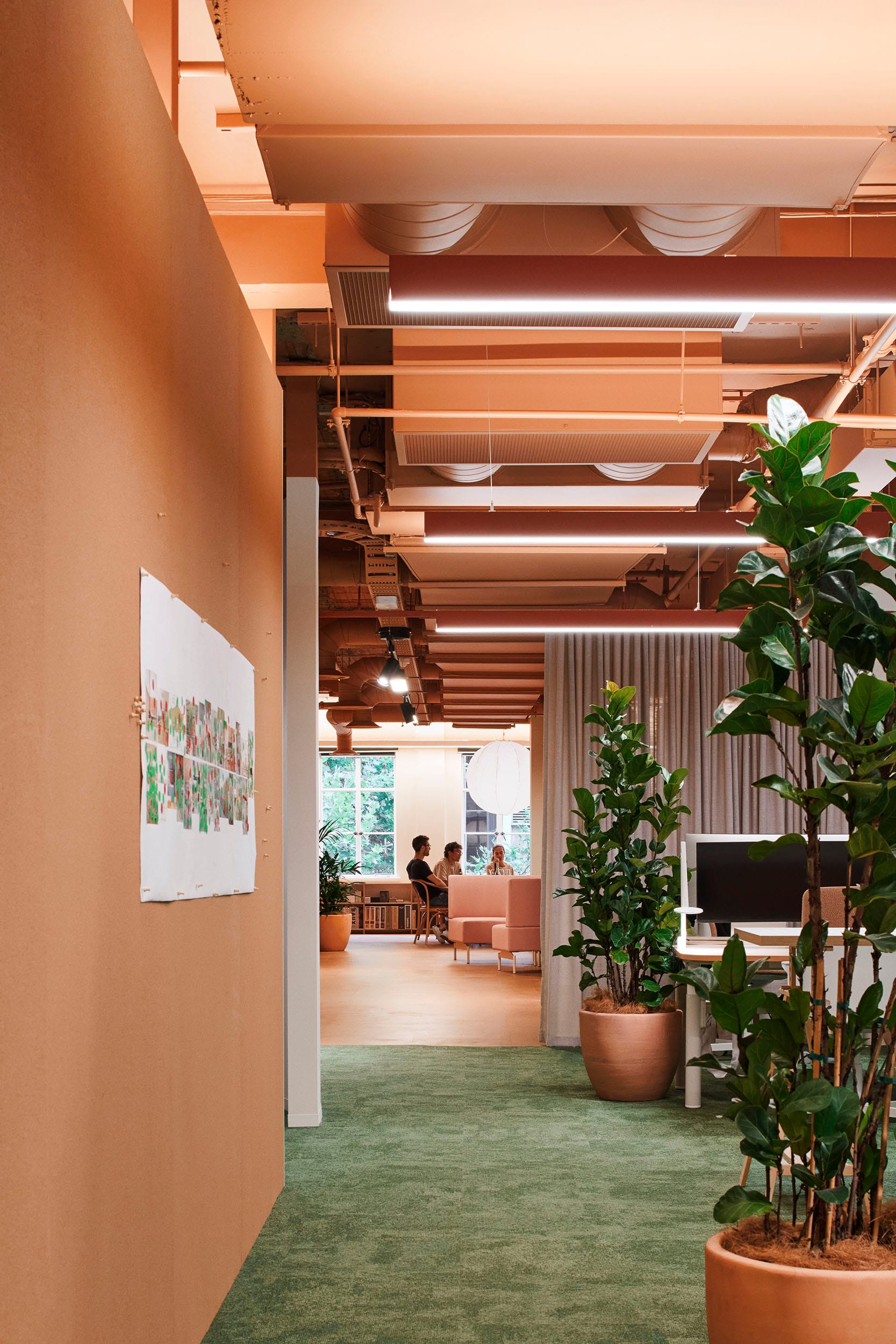 Hames Sharley Melbourne Studio by Hames Sharley. Photography by Nicole England. Office space with terracotta walls, ceilings and flooring in background. Green flooring in foreground.