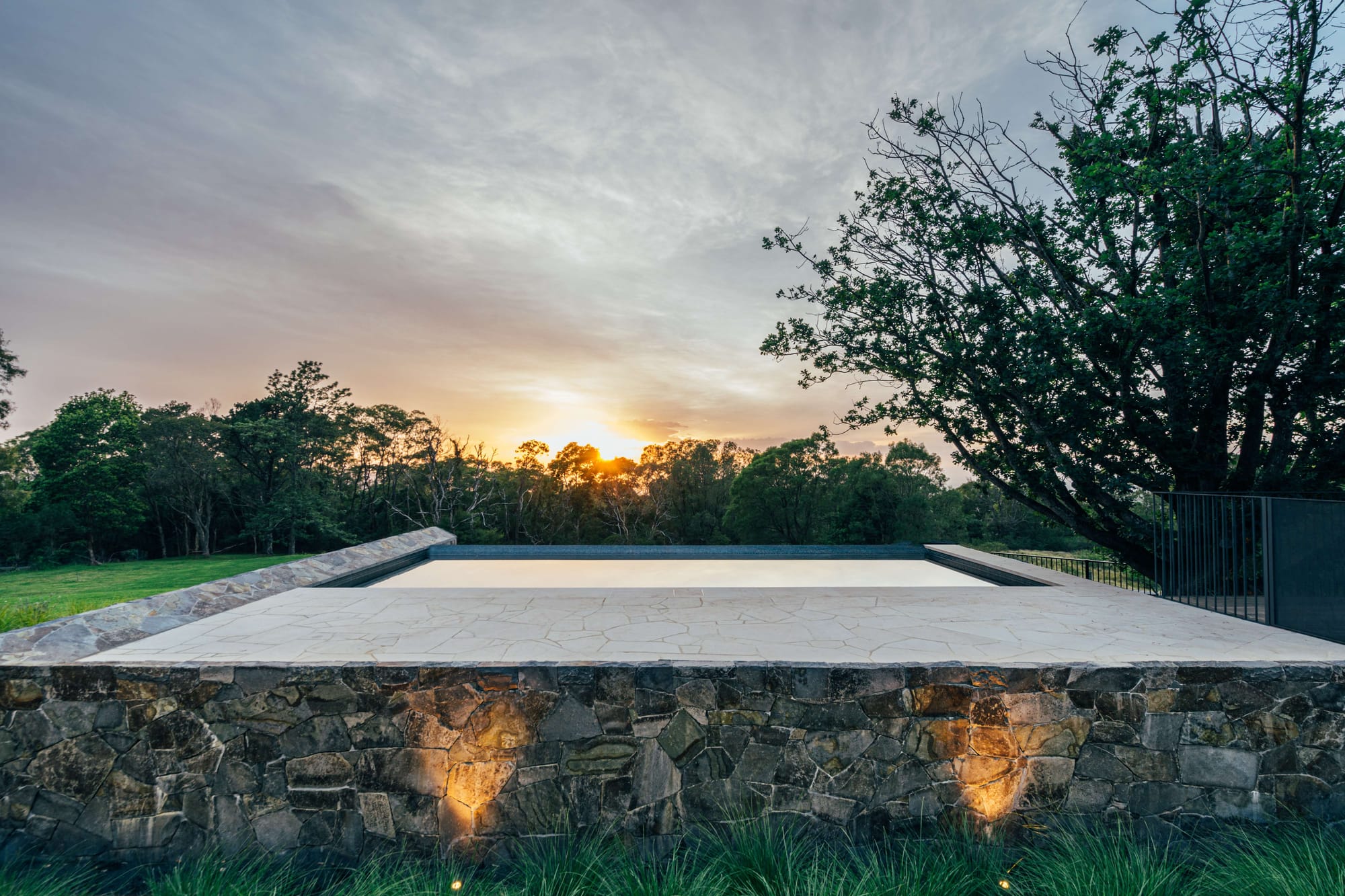 Project 465 by Robertson Collectif. Photography by Anna Mul. Pool overlooking native bushland with sunset in background. 