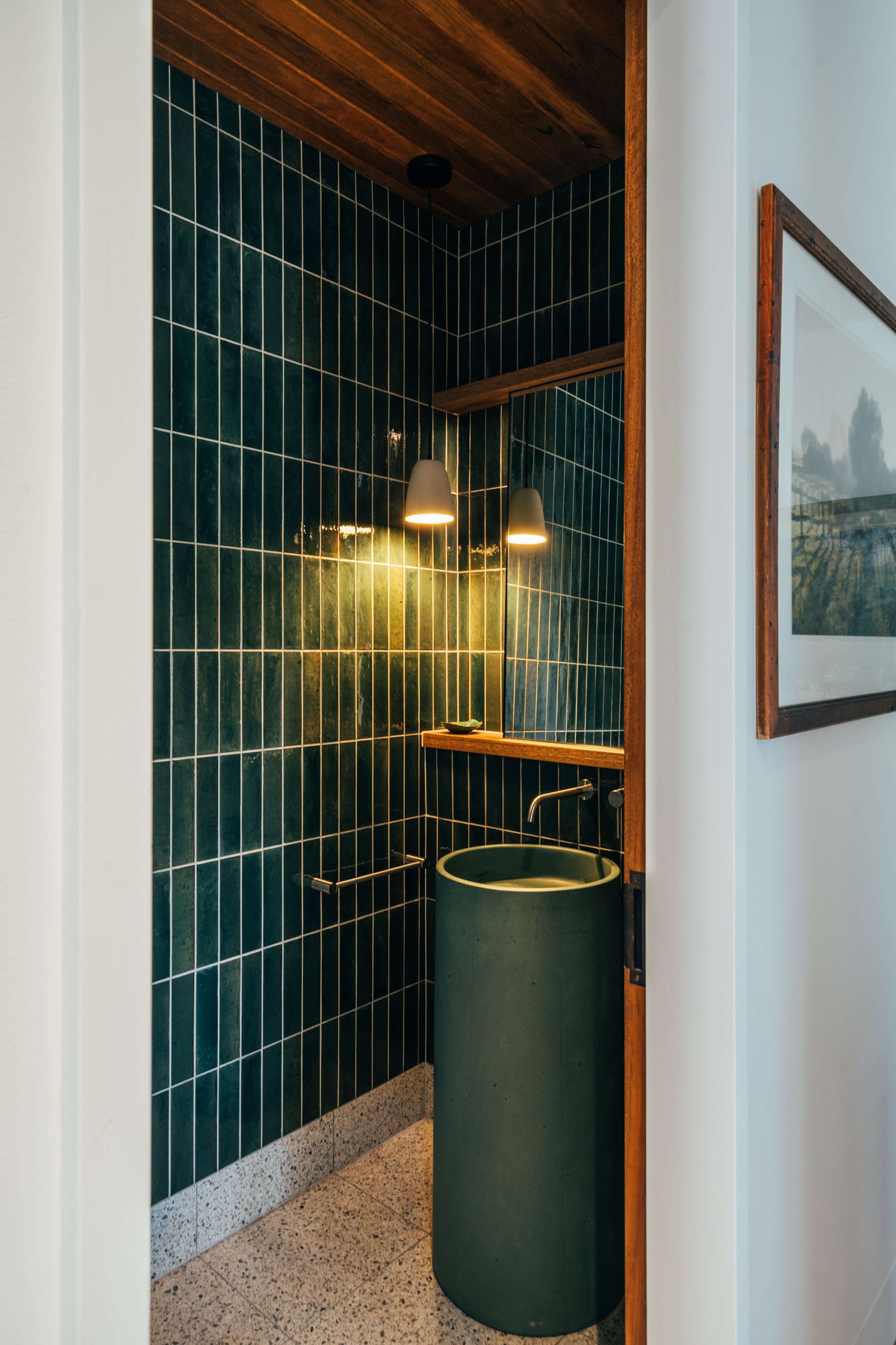 Project 465 by Robertson Collectif. Photography by Anna Mul. Bathroom with teal wall tiles and teal freestanding sink. Timber door frames and terrazzo flooring.