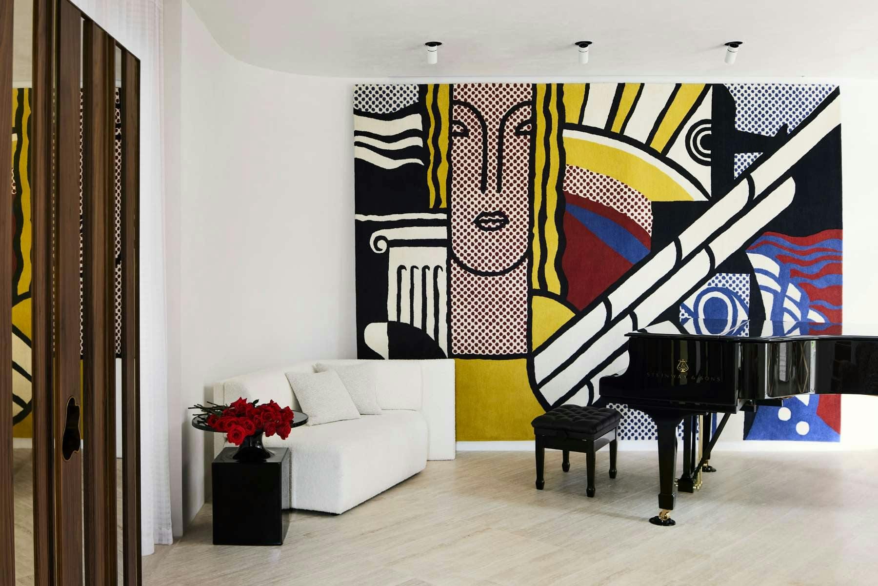 Toorak House by K.P.D.O. Living room featuring grand piano, white curved wall, art painting and wooden panel door.