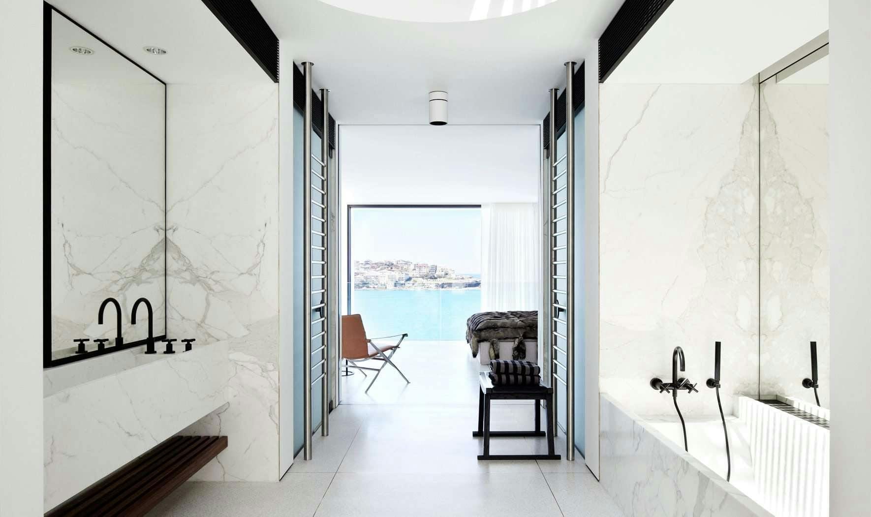 Bondi by Mathieson Architects. White marble bathroom with view to bedroom and ocean.