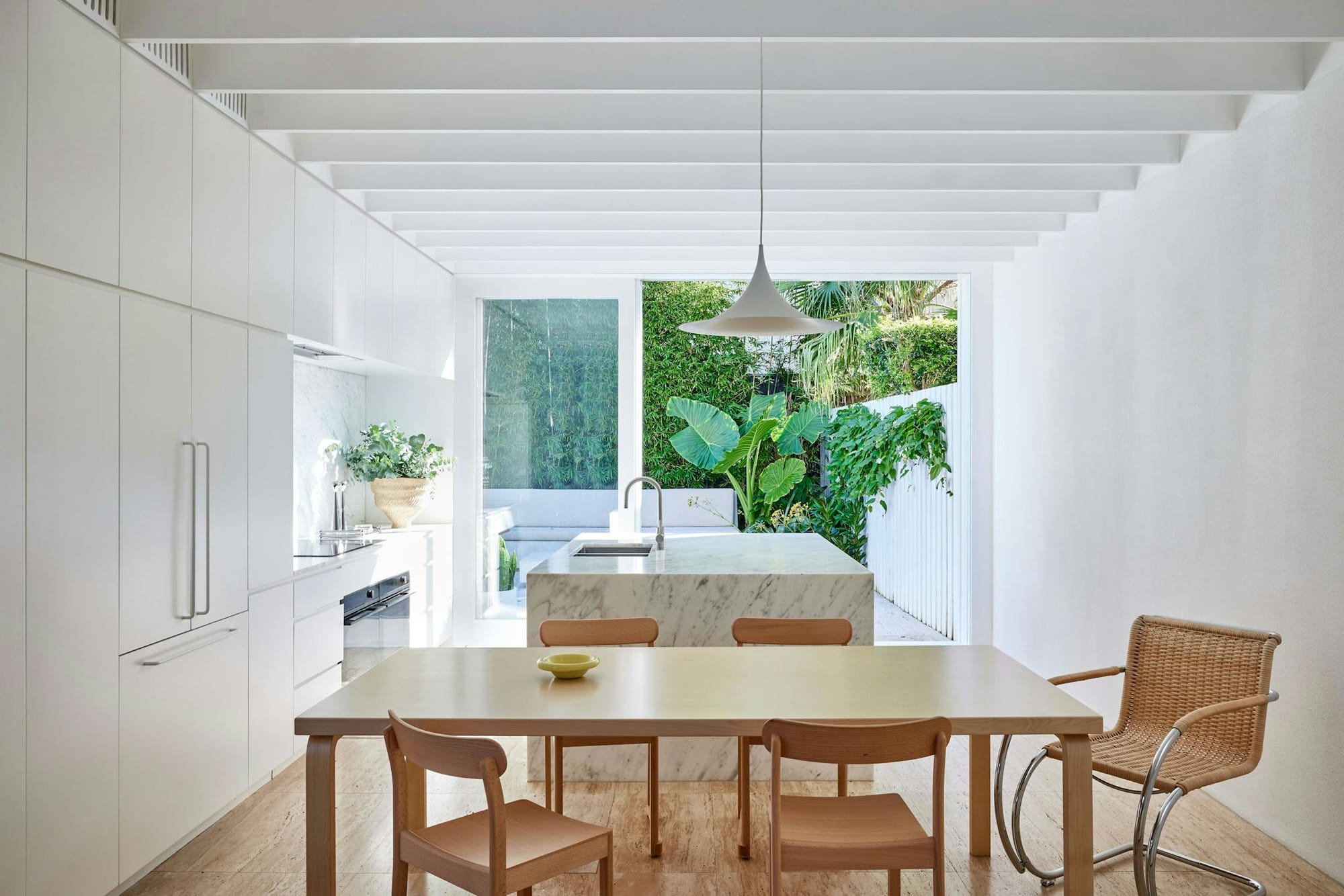 North Bondi House by Studio Arkive. Dining room, view to white marble kitchen and outdoors