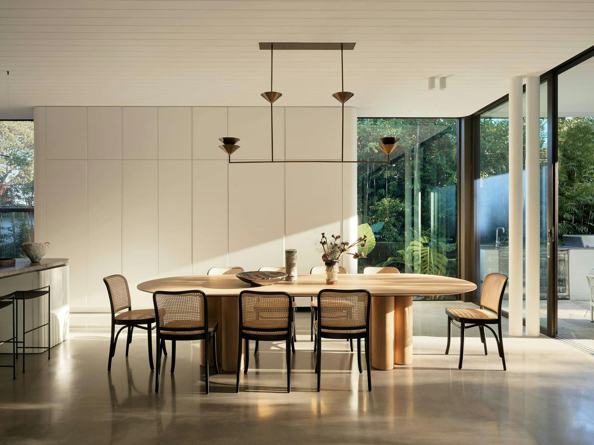 Warren House by CM Studio. Dining room featuring wooden table and thonet rattan dining chairs.