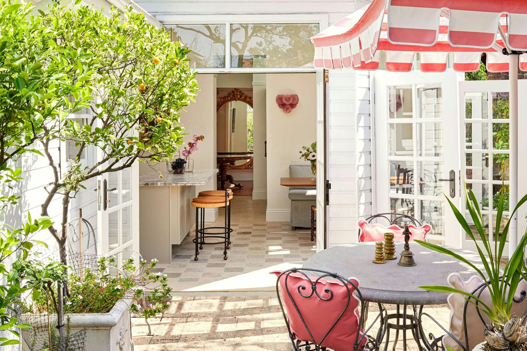 Drummoyne House by Studio Barbara. Courtyard with striped parasols, view to kitchen and dining room