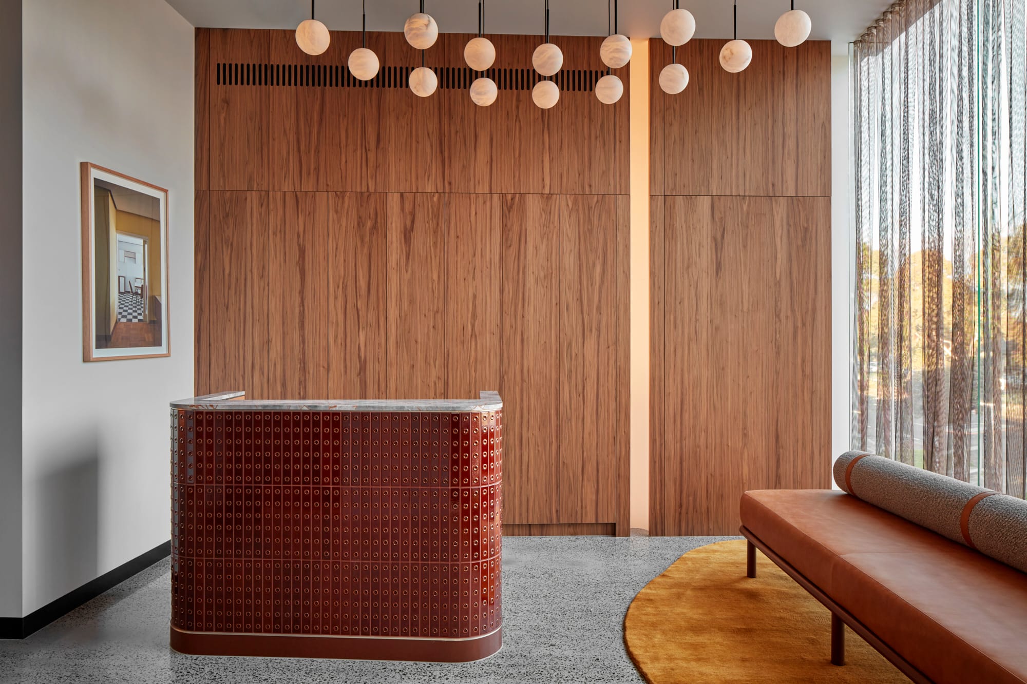 Beacon HQ by Foolscap Studio. Tiled counter with marble top featuring wooden build in cabinet and globe luminaries.