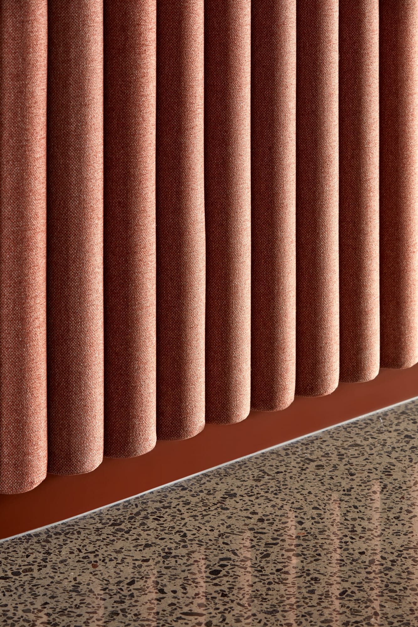 Beacon HQ by Foolscap Studio. Detail shot of laminated terrazzo screed and orange fabric acoustic installation.  