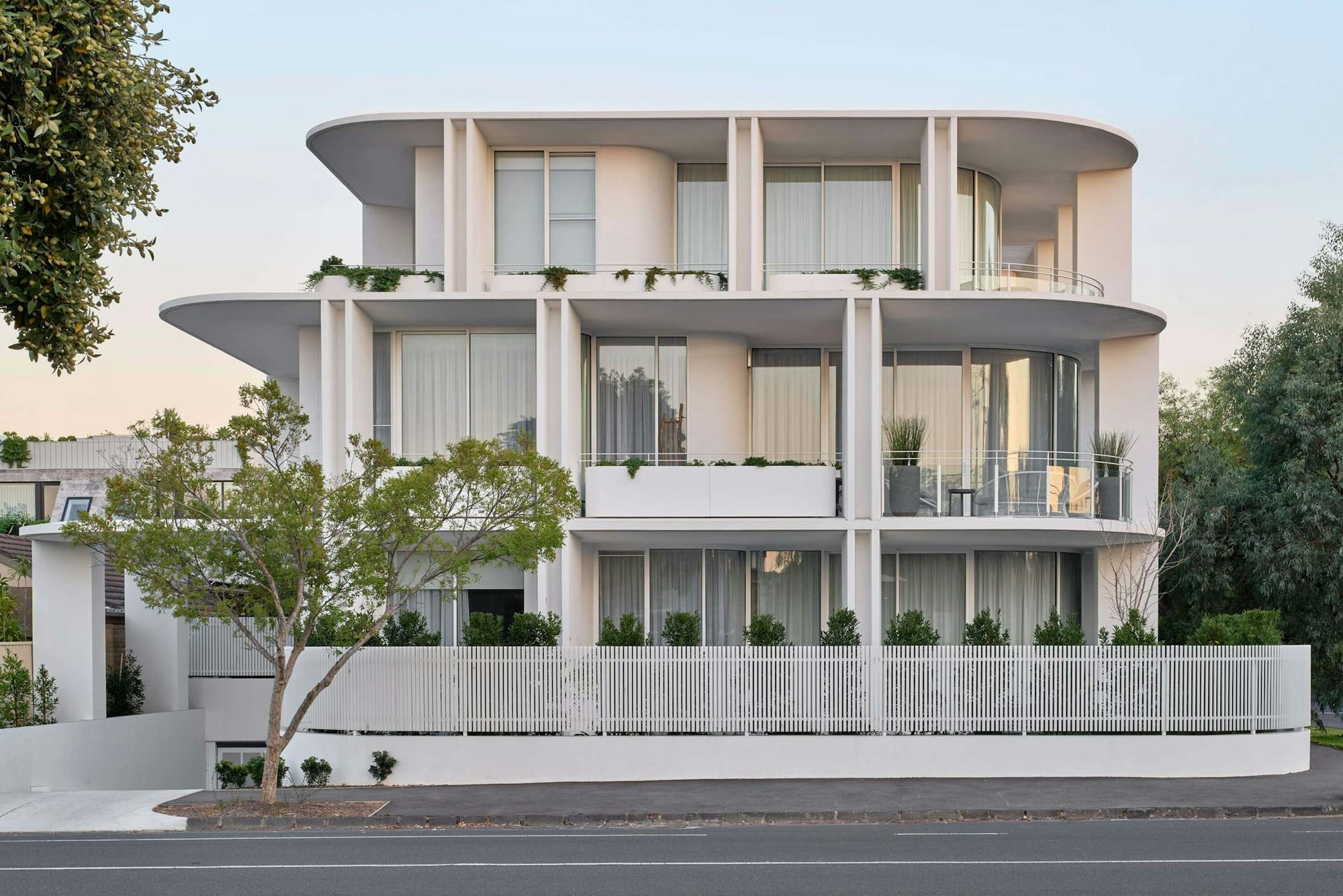 An exterior shot of the white apartment building by Merrylees Architecture showing the curved form