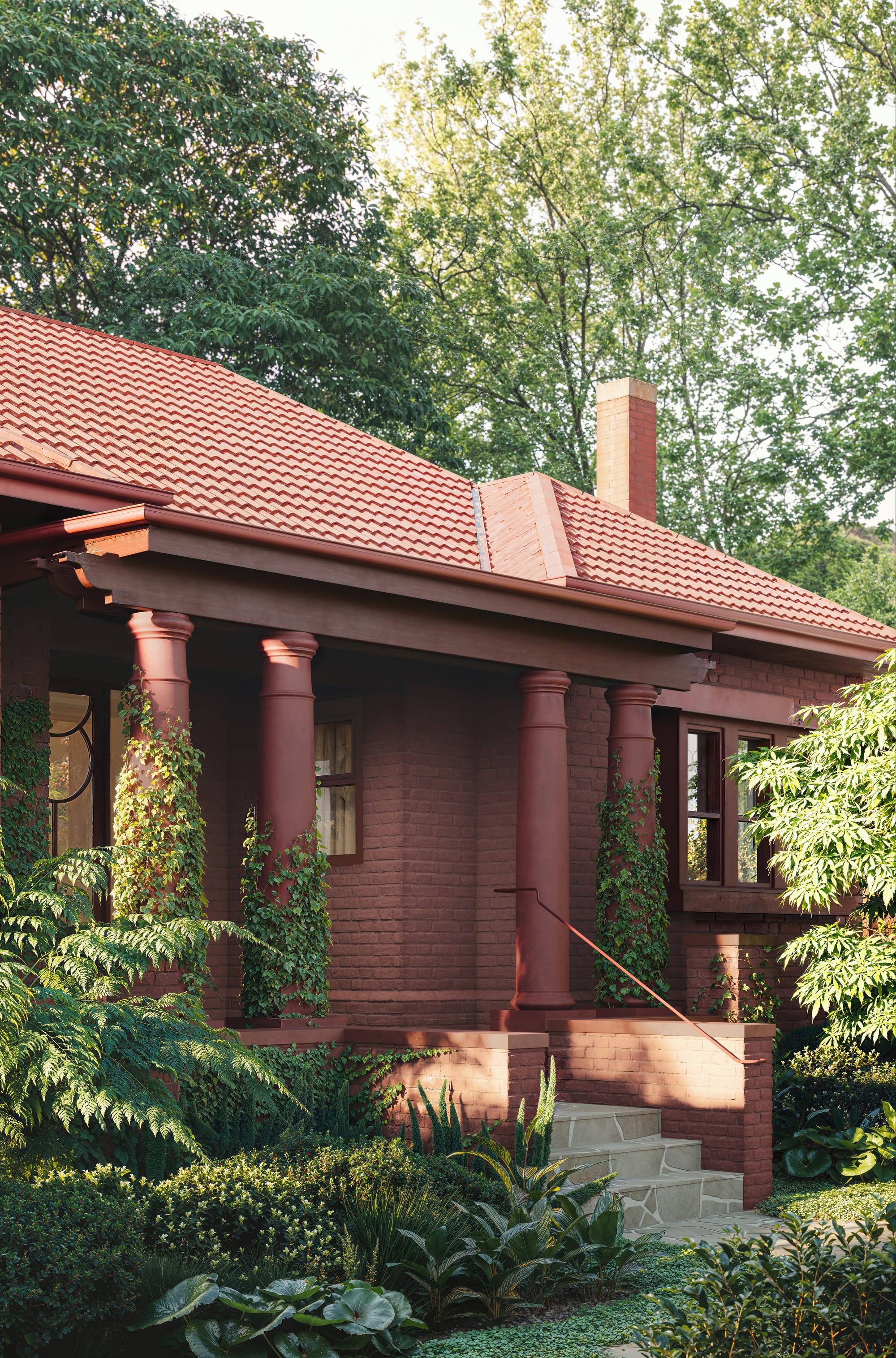 Fernhurst by ANGLE. Outdoor view on red brick house with columns entrance and surrounding greenery.