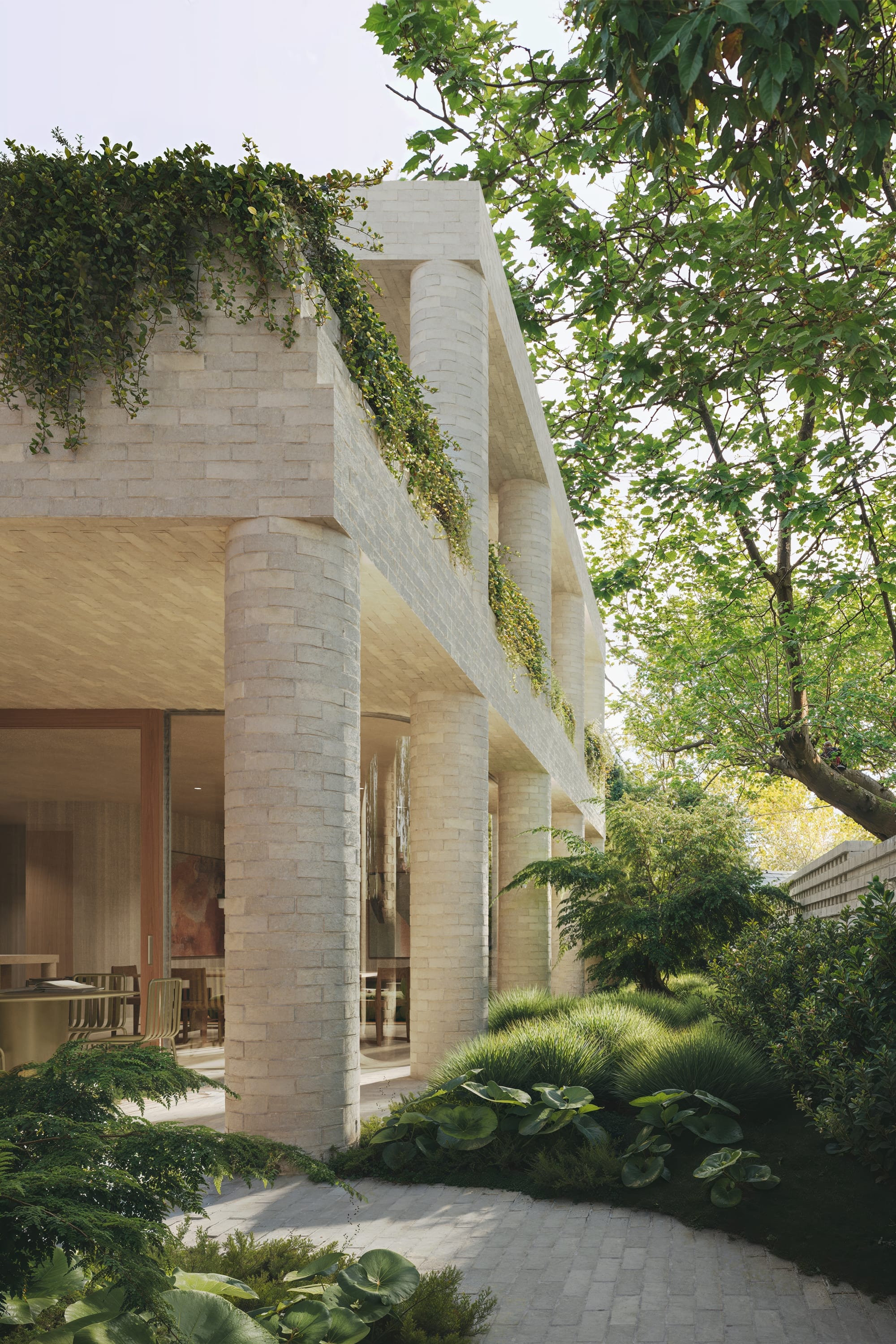 Fernhurst by ANGLE. Outside view on cement brick facade with supporting columns, floor to ceiling windows and nature.