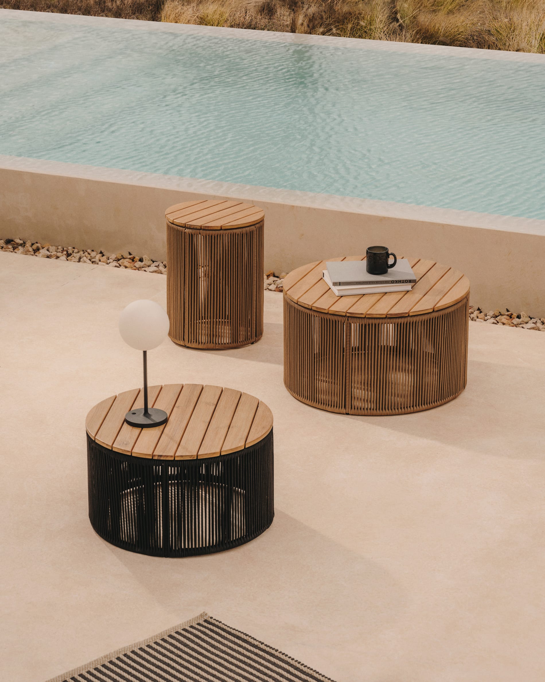 Kave Home. Round outdoor coffee tables with wood panel top.