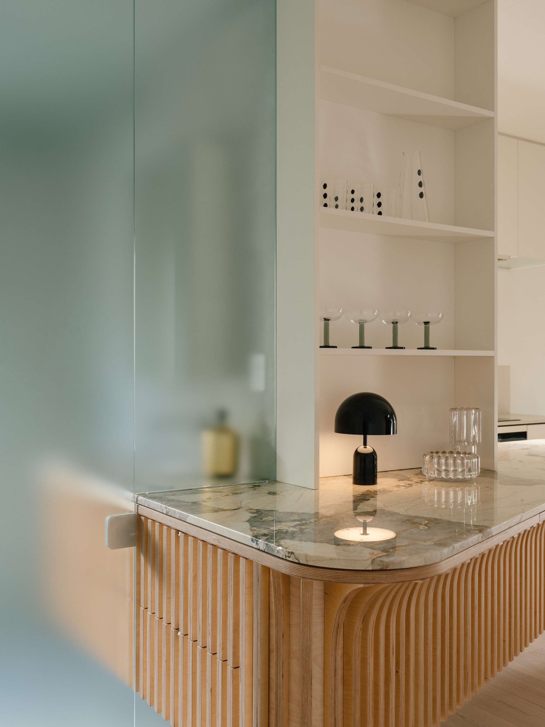 Kirribilli Downsize Apartment by Amandine & Simonetti Architecture. Kitchen counter with marble work top and 'bell table lamp' by Tom Dixon.