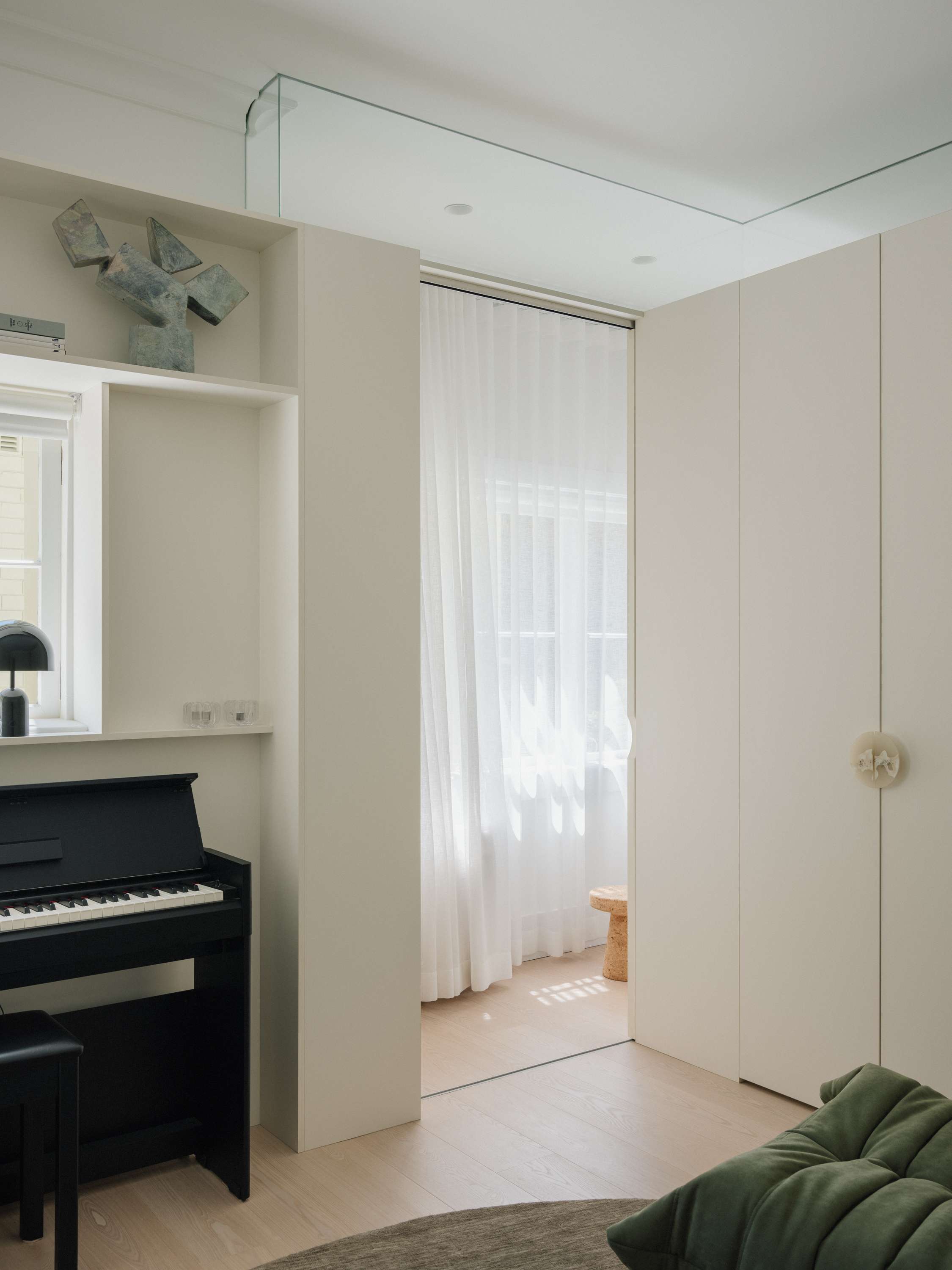 Kirribilli Downsize Apartment by Amandine & Simonetti Architecture. Living room featuring 'lazy caterpillar lounge chair' by Michel Ducaroy and piano.