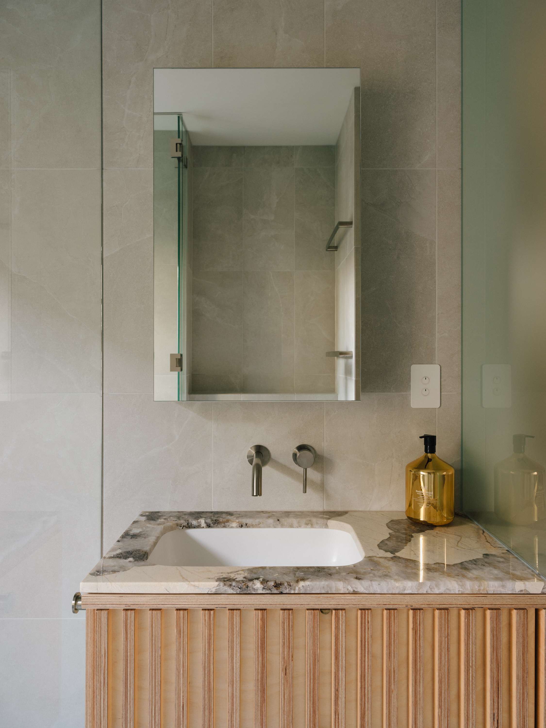 Kirribilli Downsize Apartment by Amandine & Simonetti Architecture. Plywood bathroom cabinet with marble top and concealed tap.  