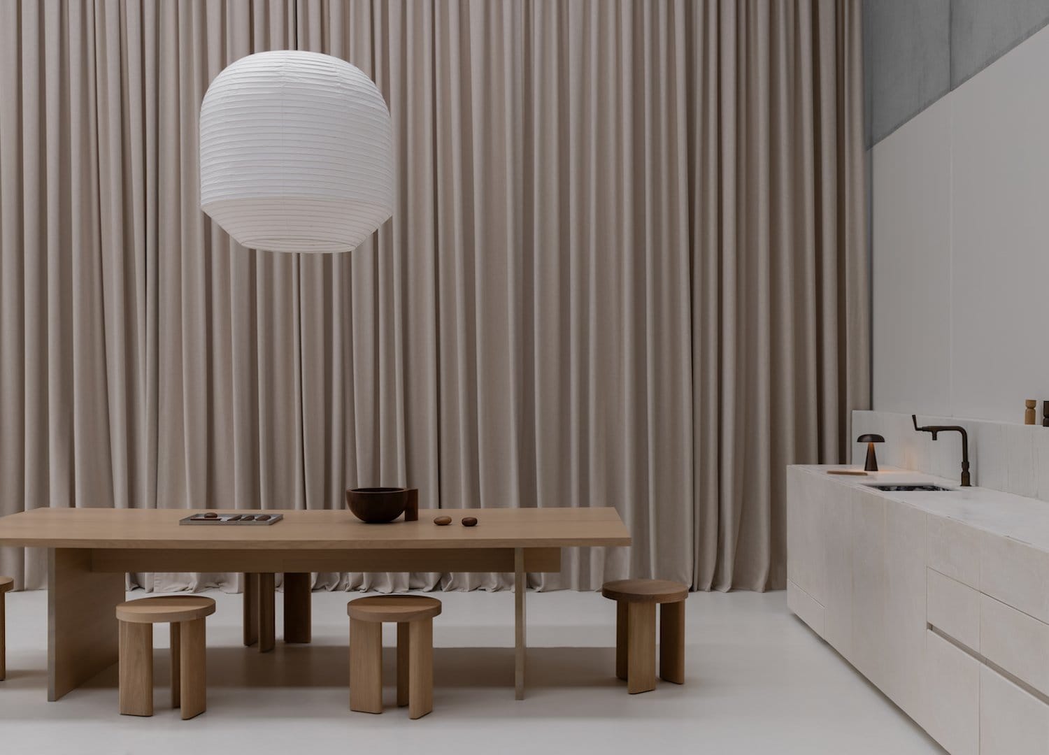 An interior shot of the Linear Standard showroom with a timber meeting table and a large pendant light over