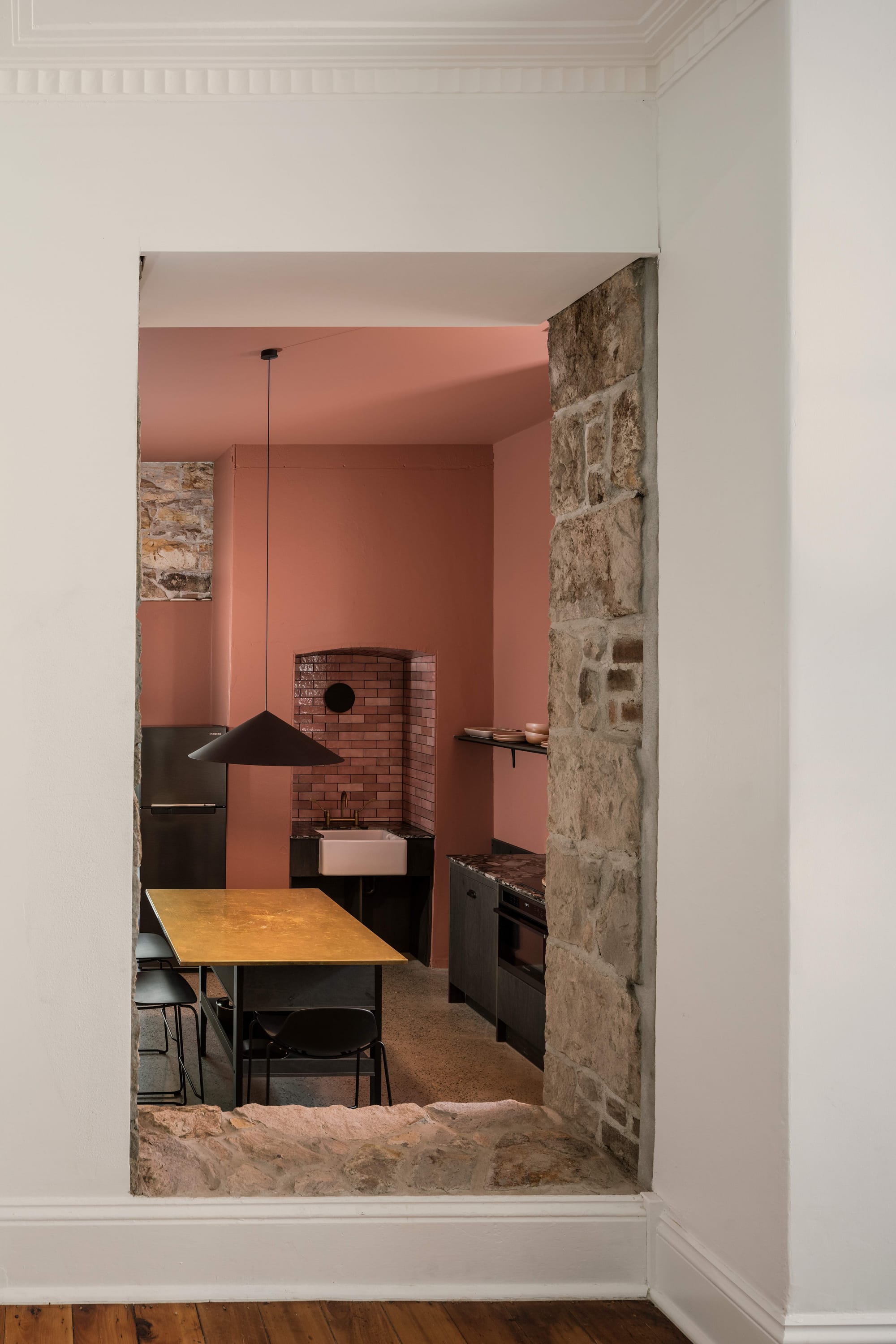 An interior shot of Miss Midgleys showing a view into the kitchen space with pink and white walls