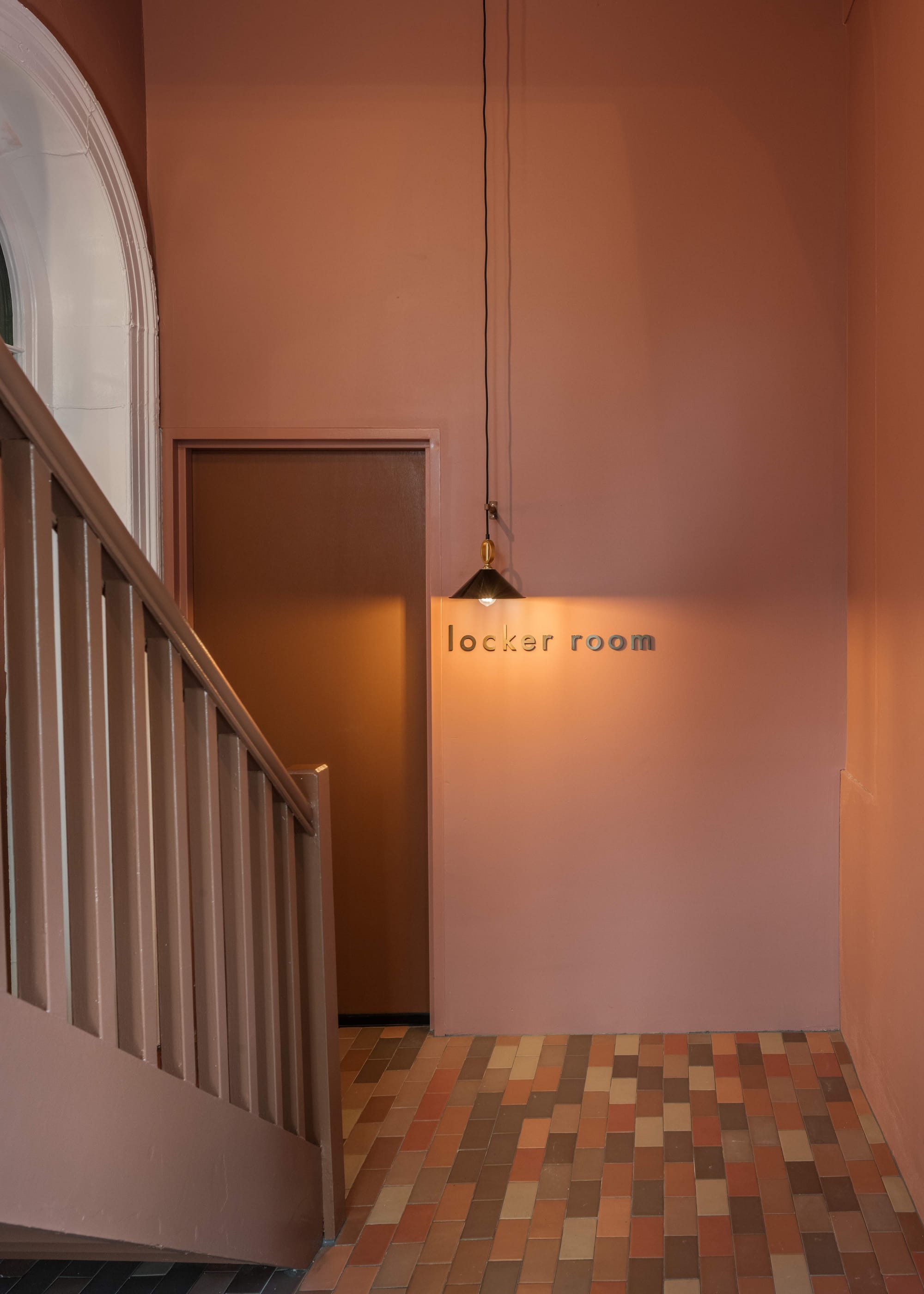 An interior shot of Miss Midgleys showing the communal staircase with mixed tiles on the floor and pink walls