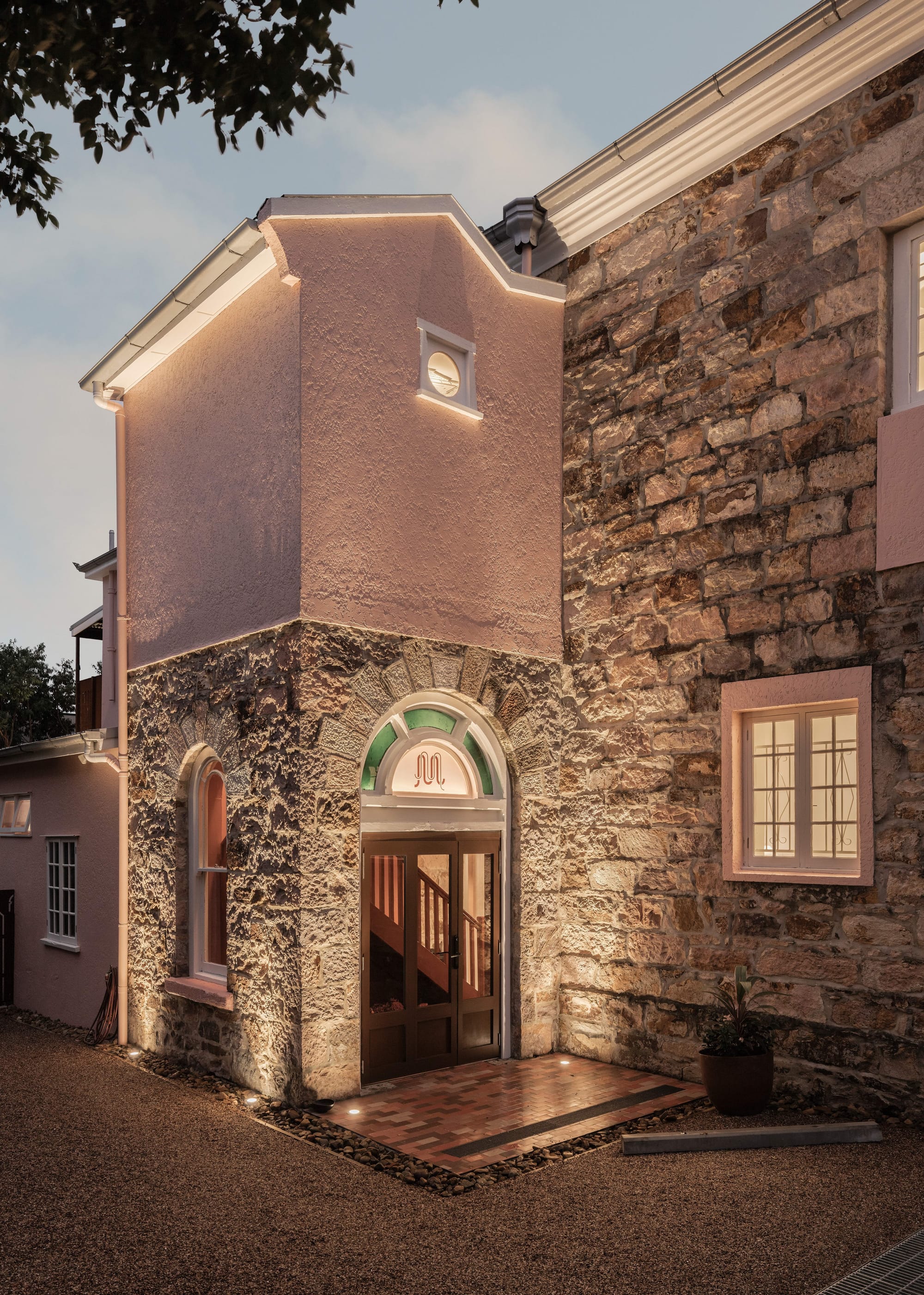 An exterior shot of Miss Midgleys showing an entry door and the sandstone walls and pink render