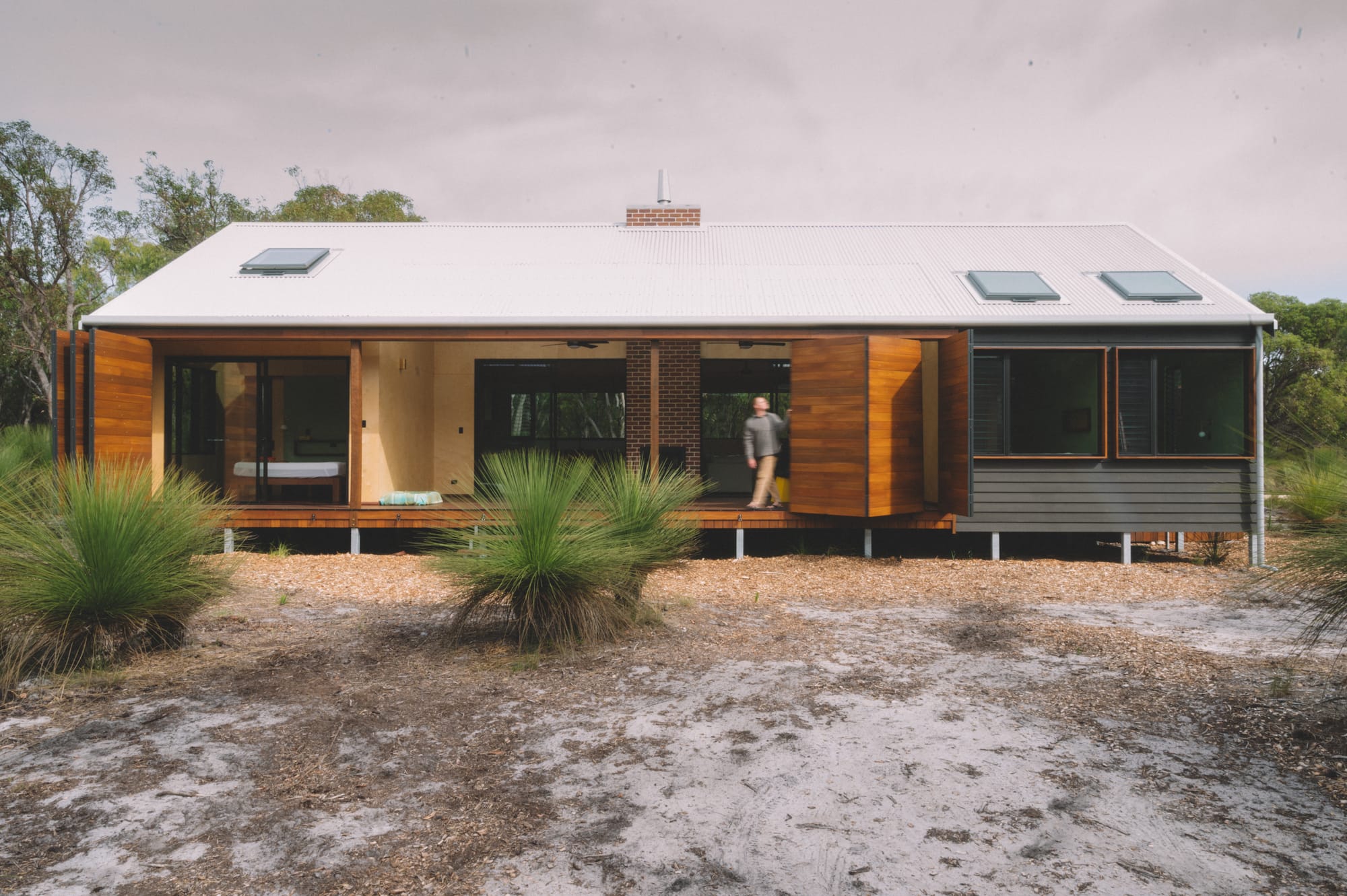 Nullaki House by Bare Architects. View on stilt minimalistic house with Japanese aesthetic and bifold door facade.