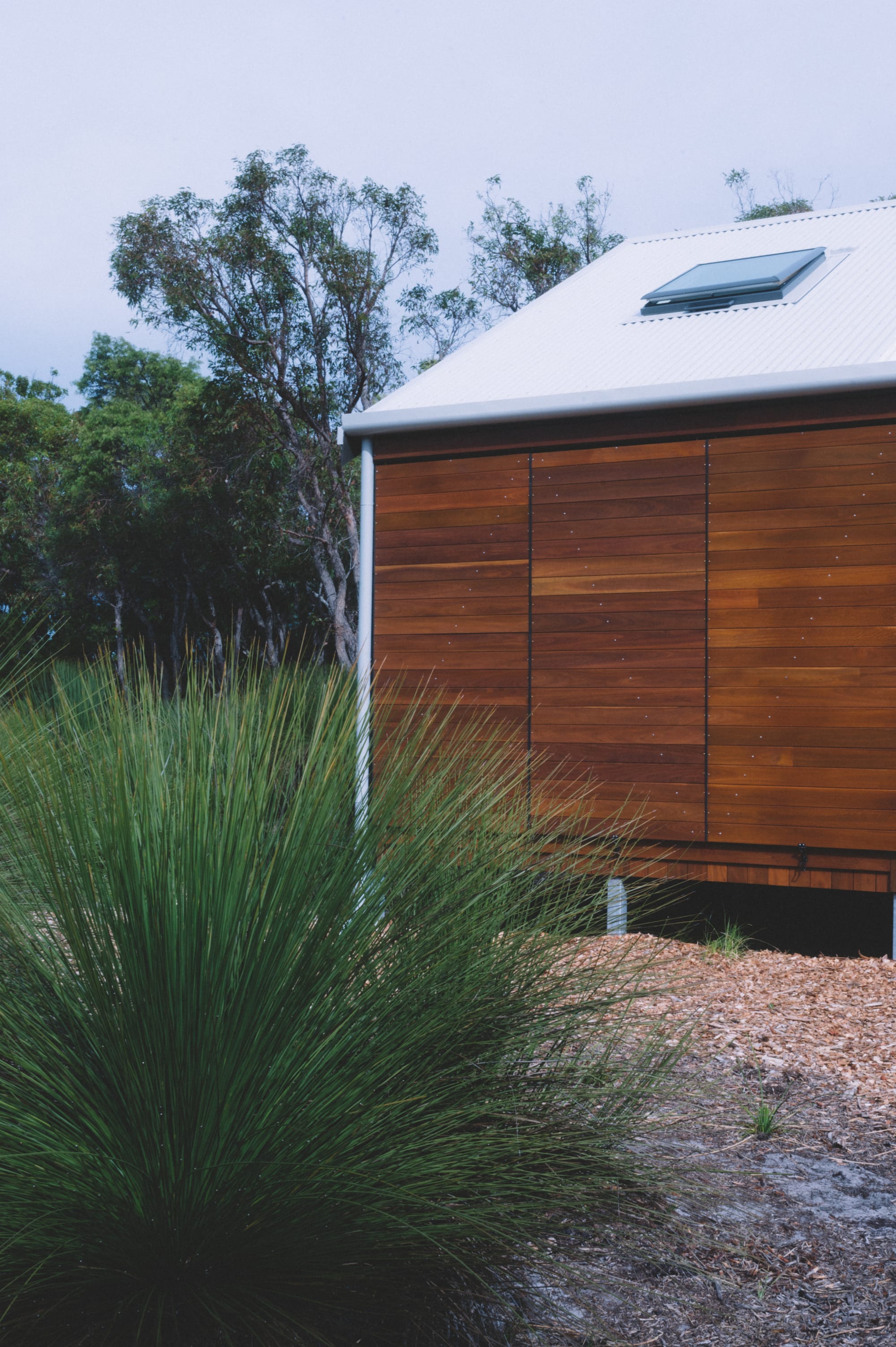 Nullaki House by Bare Architects. View on facade with bifold doors and custom-fabricated gutters and downpipes.