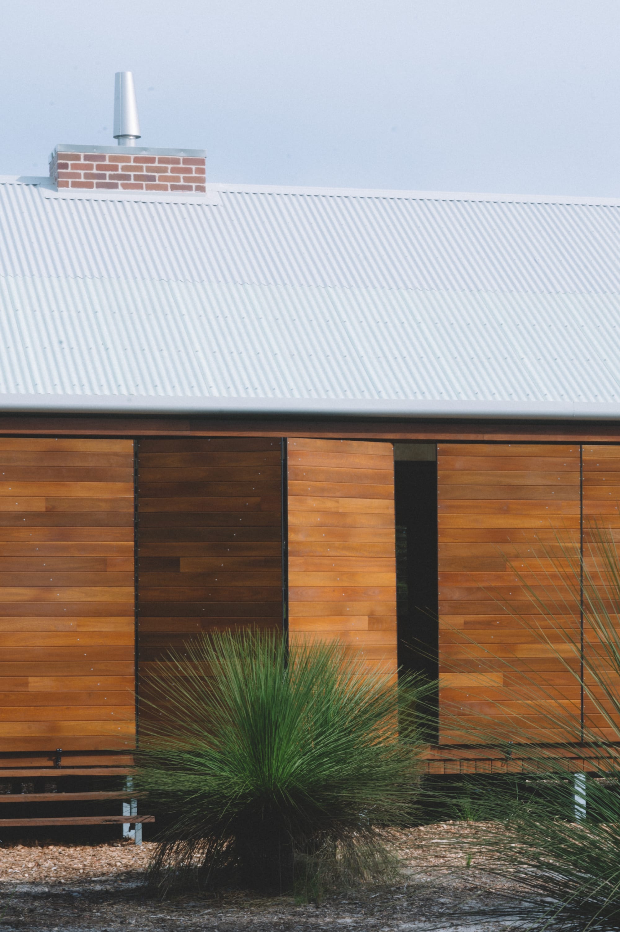 Nullaki House by Bare Architects. Minimalistic house on stilts featuring wood panel, bifold doors.