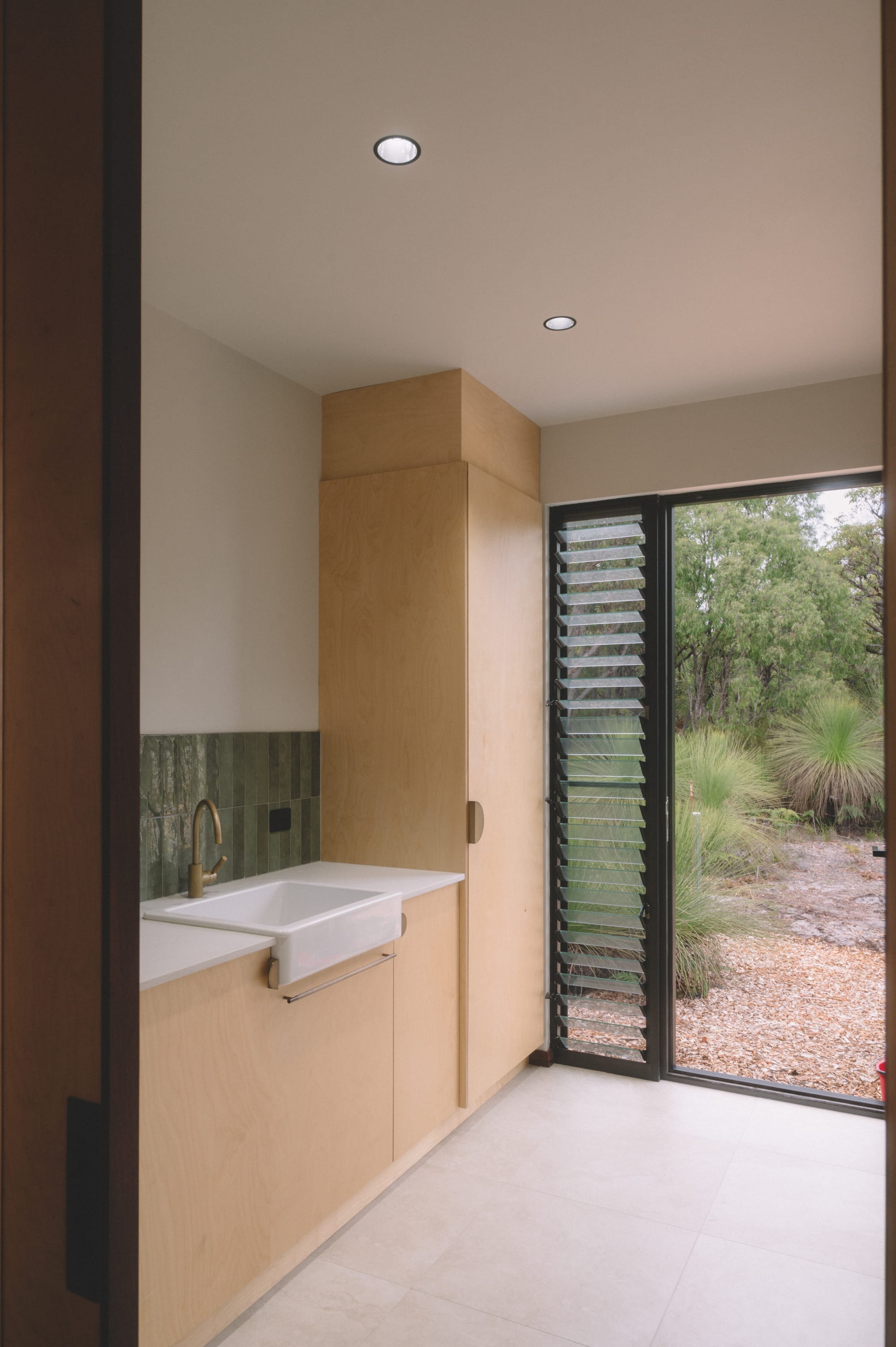 Nullaki House by Bare Architects. Bathroom featuring floor to ceiling glass doors and view to nature.